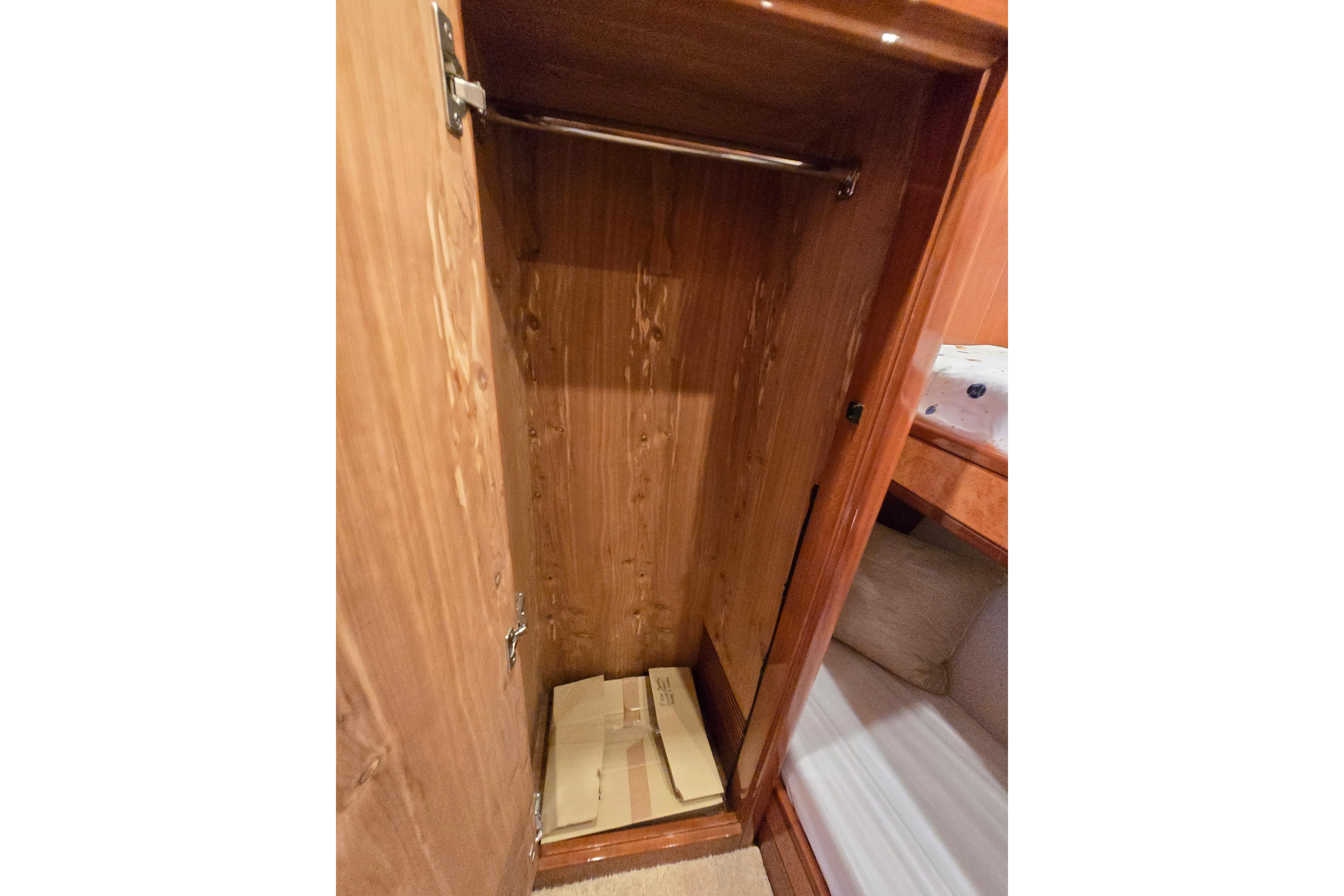 Empty wooden closet inside a 2004 Grand Harbour 58 yacht, featuring a hanging rod.