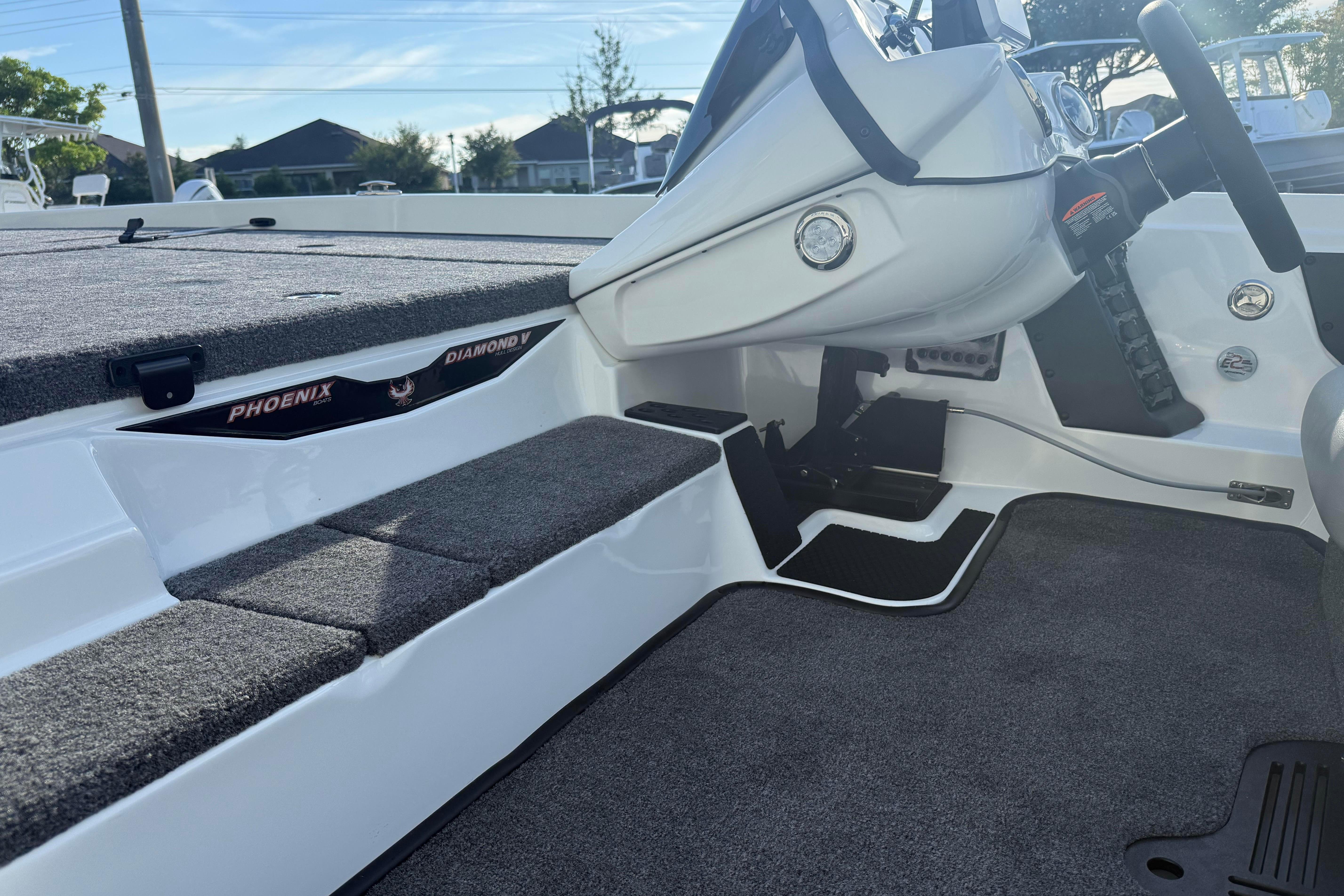 2027 Phoenix 721 ZXL boat interior with carpeted steps and steering console.