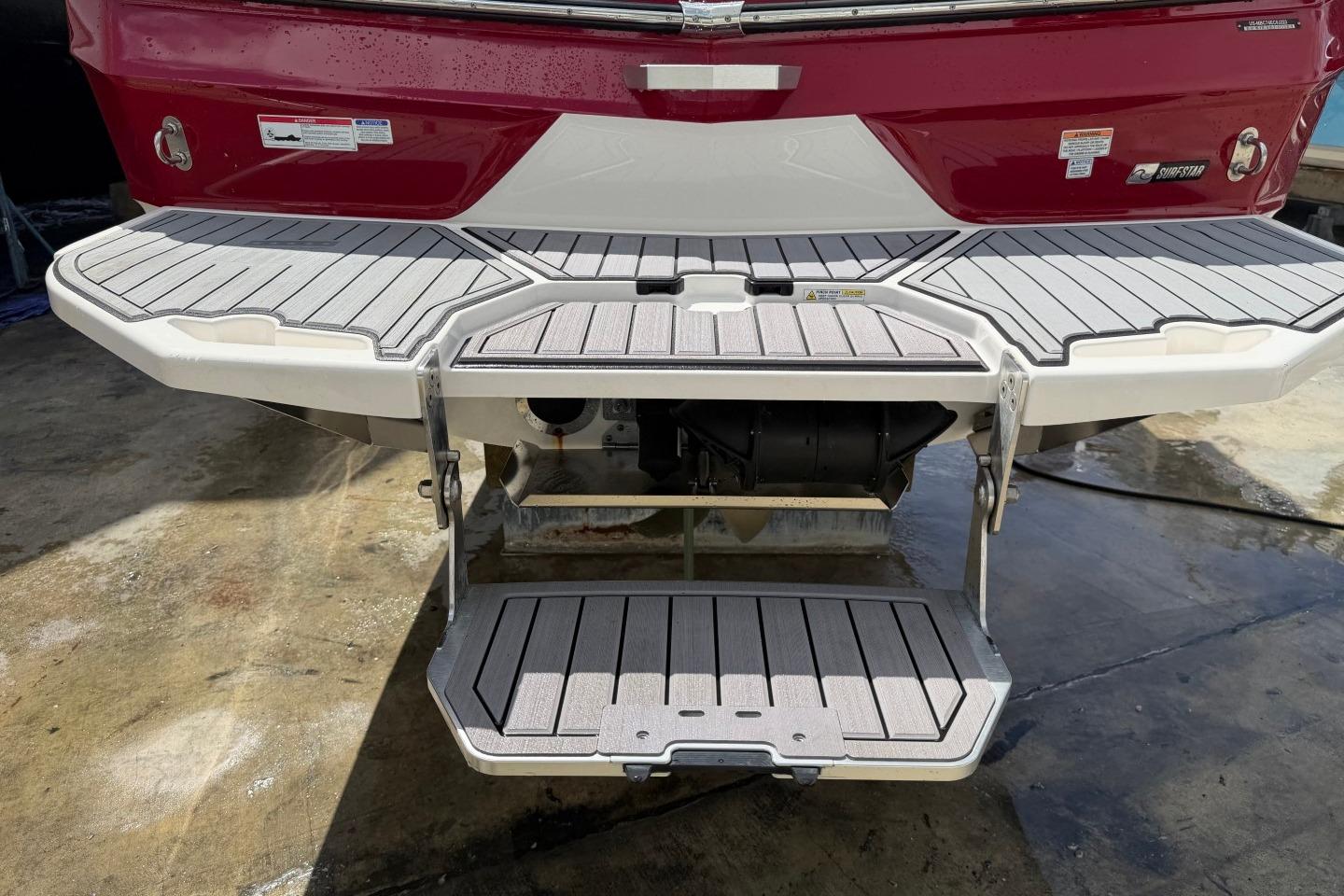 2023 MasterCraft X24 boat with extended swim platform and step ladder.