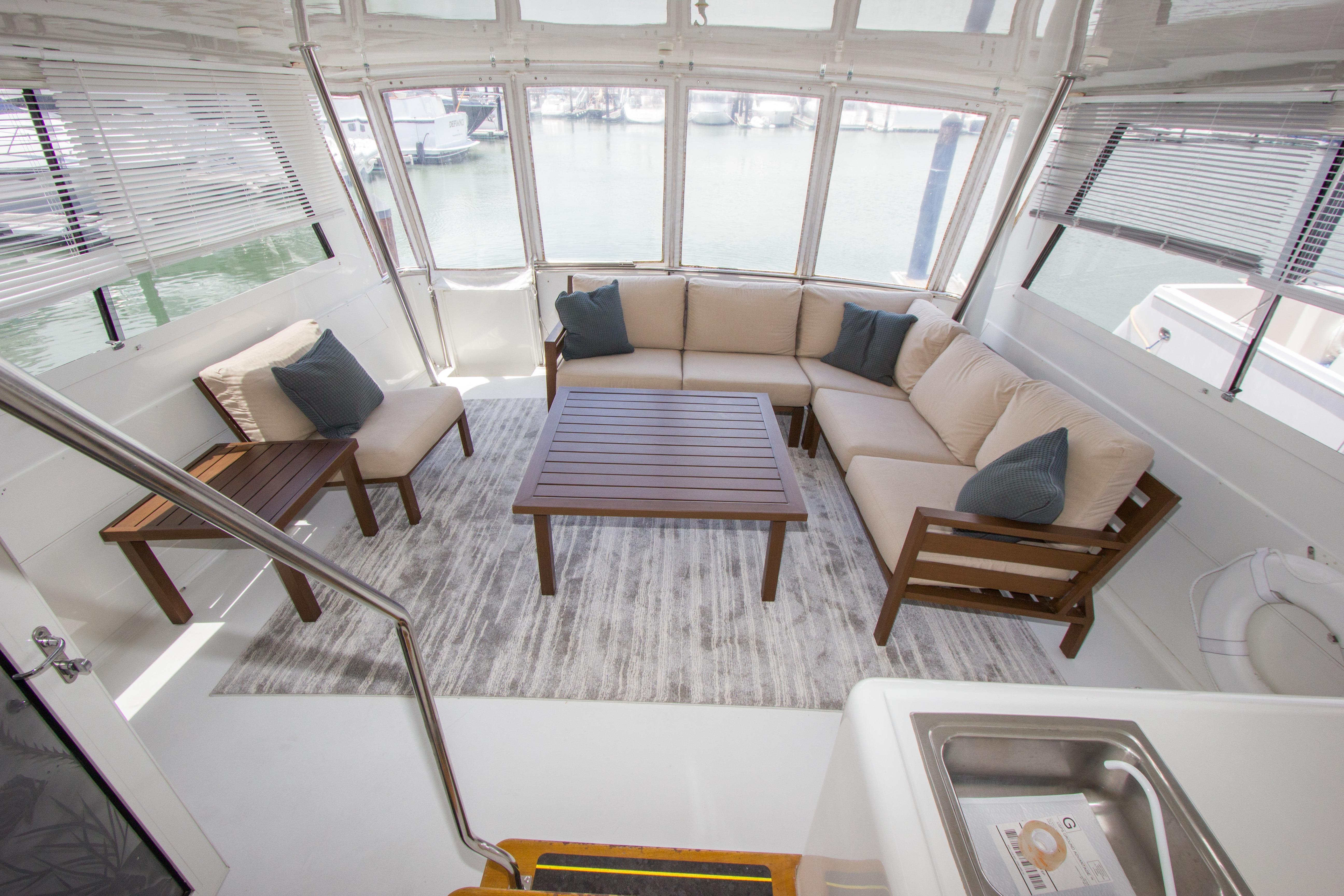 Luxurious interior of 1994 Hatteras 52 Cockpit Motor Yacht with elegant seating and wooden table.