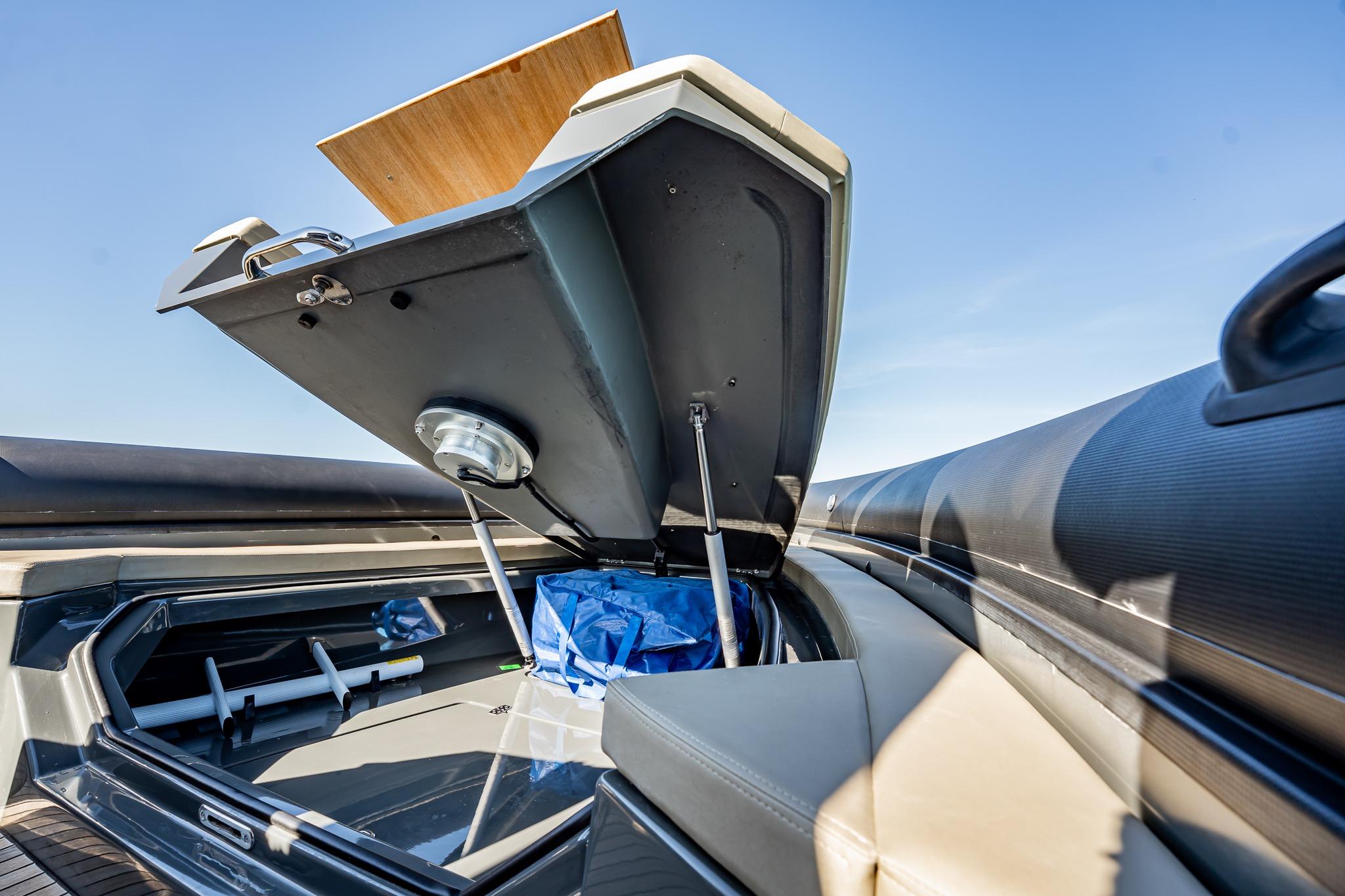 Open storage compartment on 2023 Skipper-BSK 38NC boat under clear blue sky.