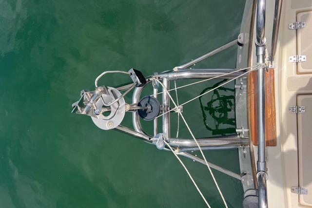 Bow of 1991 Caliber 33 sailboat with anchor and rigging over water.