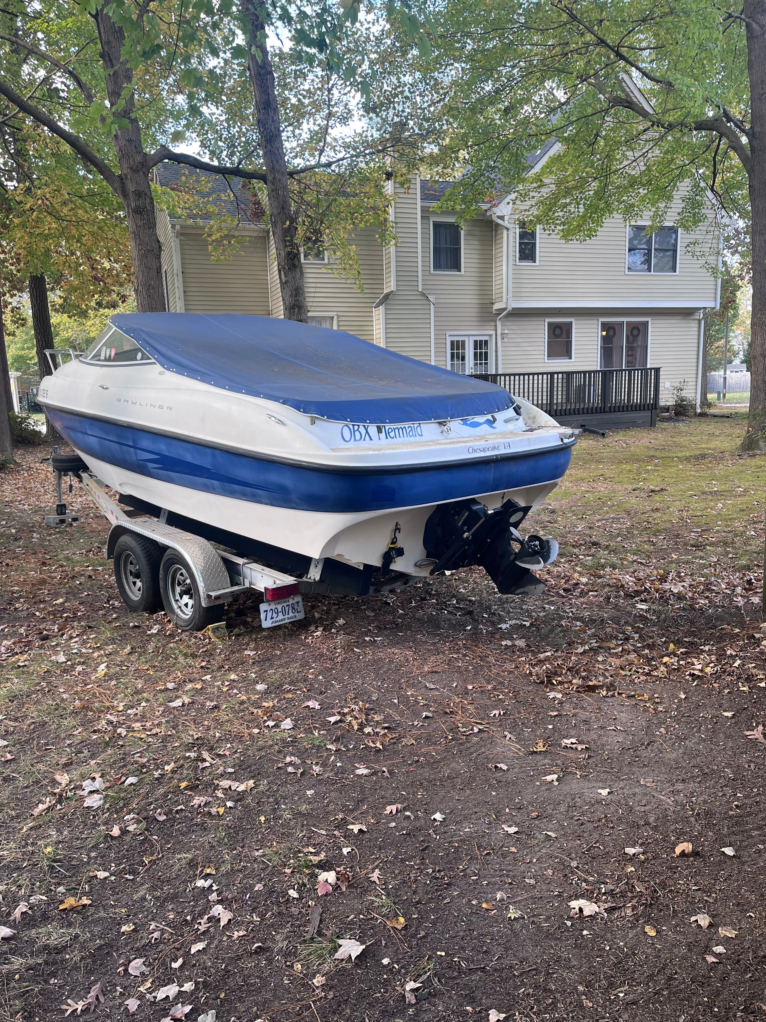2005 Bayliner Cuddy Capri boat on trailer in yard.
