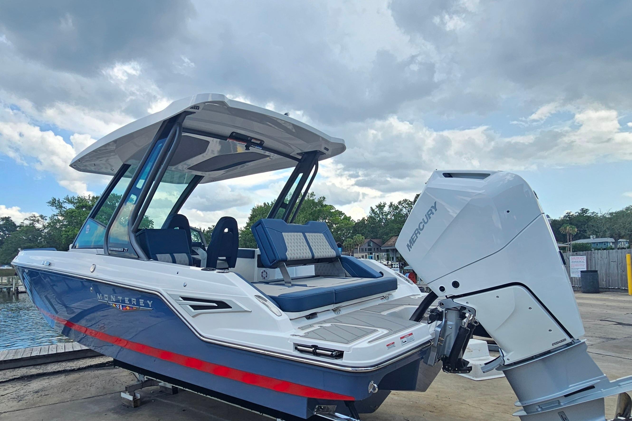 2026 Monterey Elite 27 OB boat with Mercury outboard engine, docked under cloudy sky.