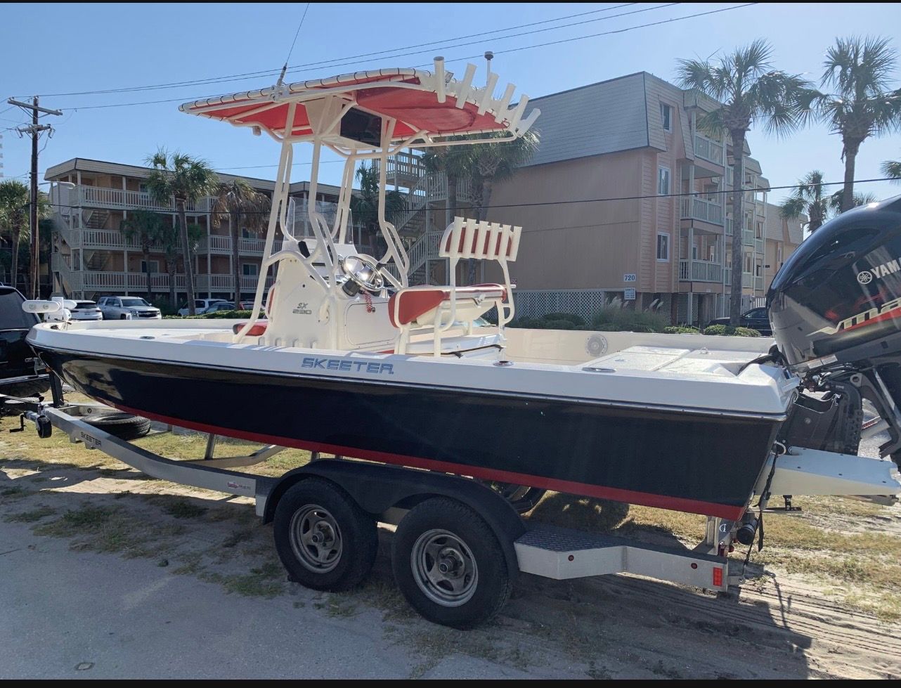 2016 Skeeter SX230 boat on trailer, parked near buildings.