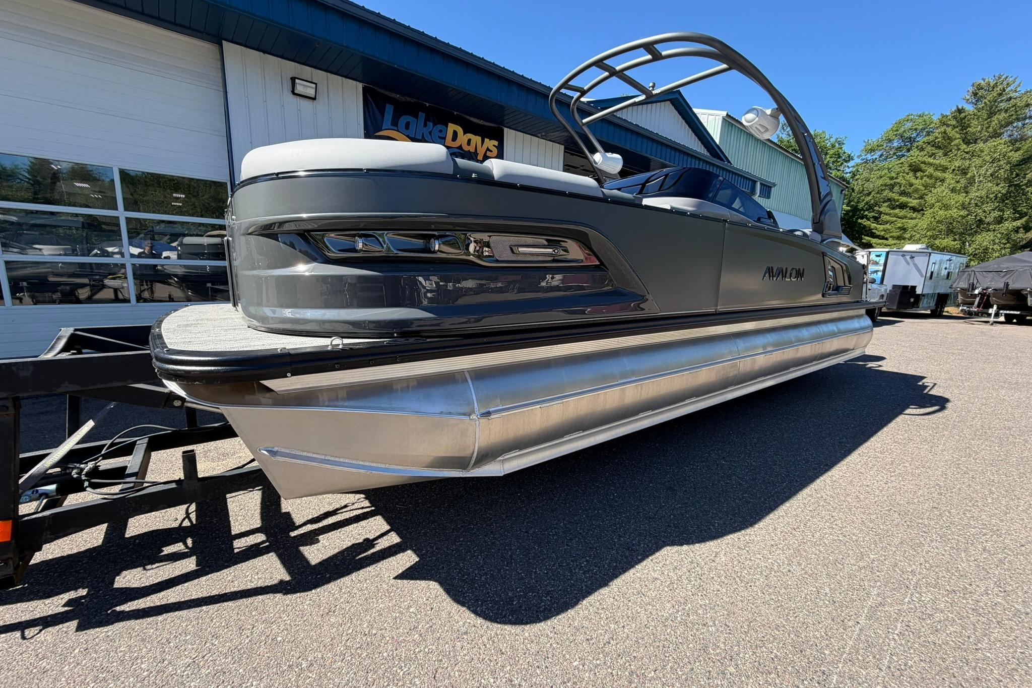2026 Avalon Excalibur LTD Quad Lounge pontoon boat at dealership, side view.