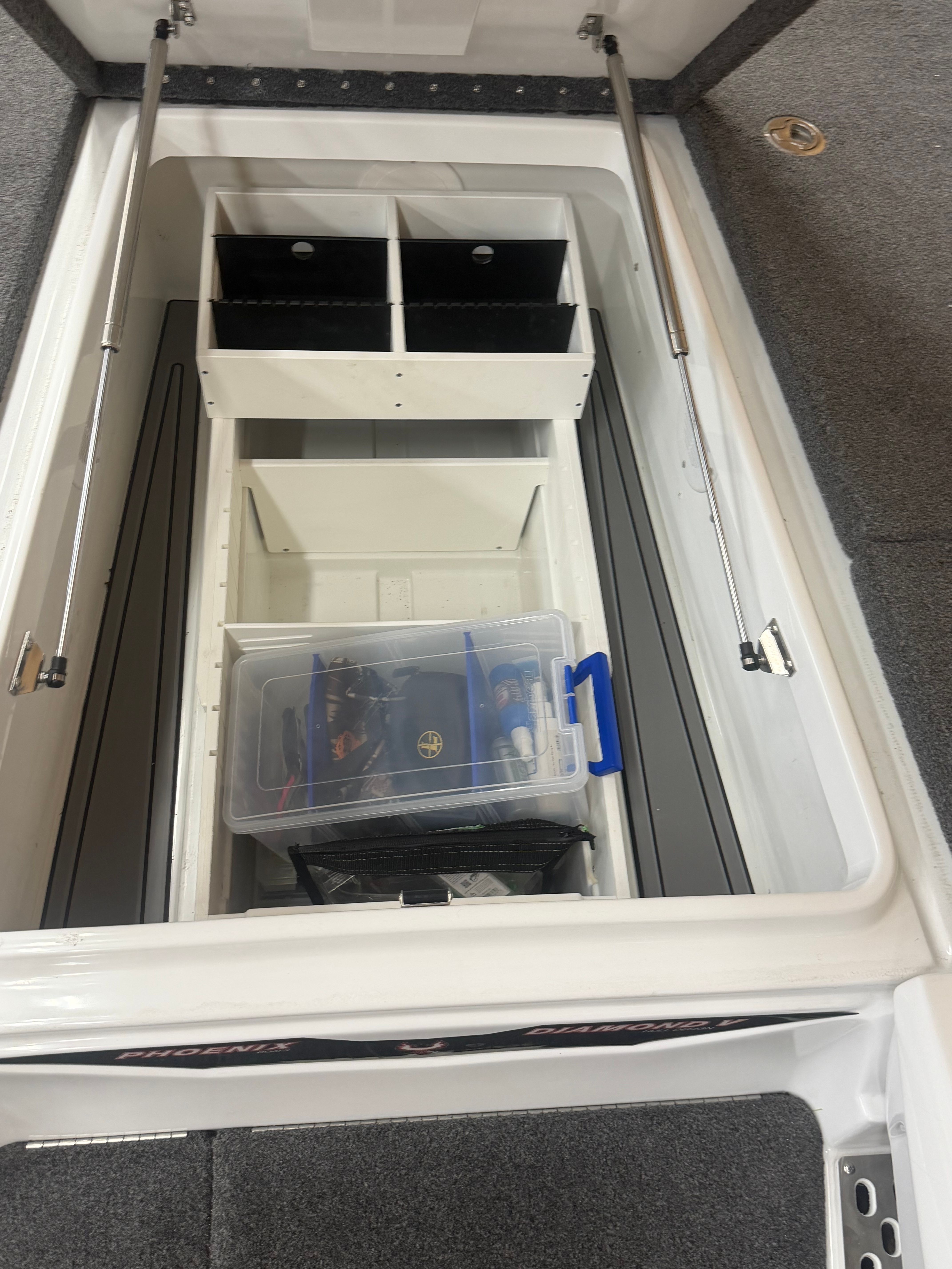 Interior view of a Phoenix 920 Elite boat with storage compartments and fishing gear.