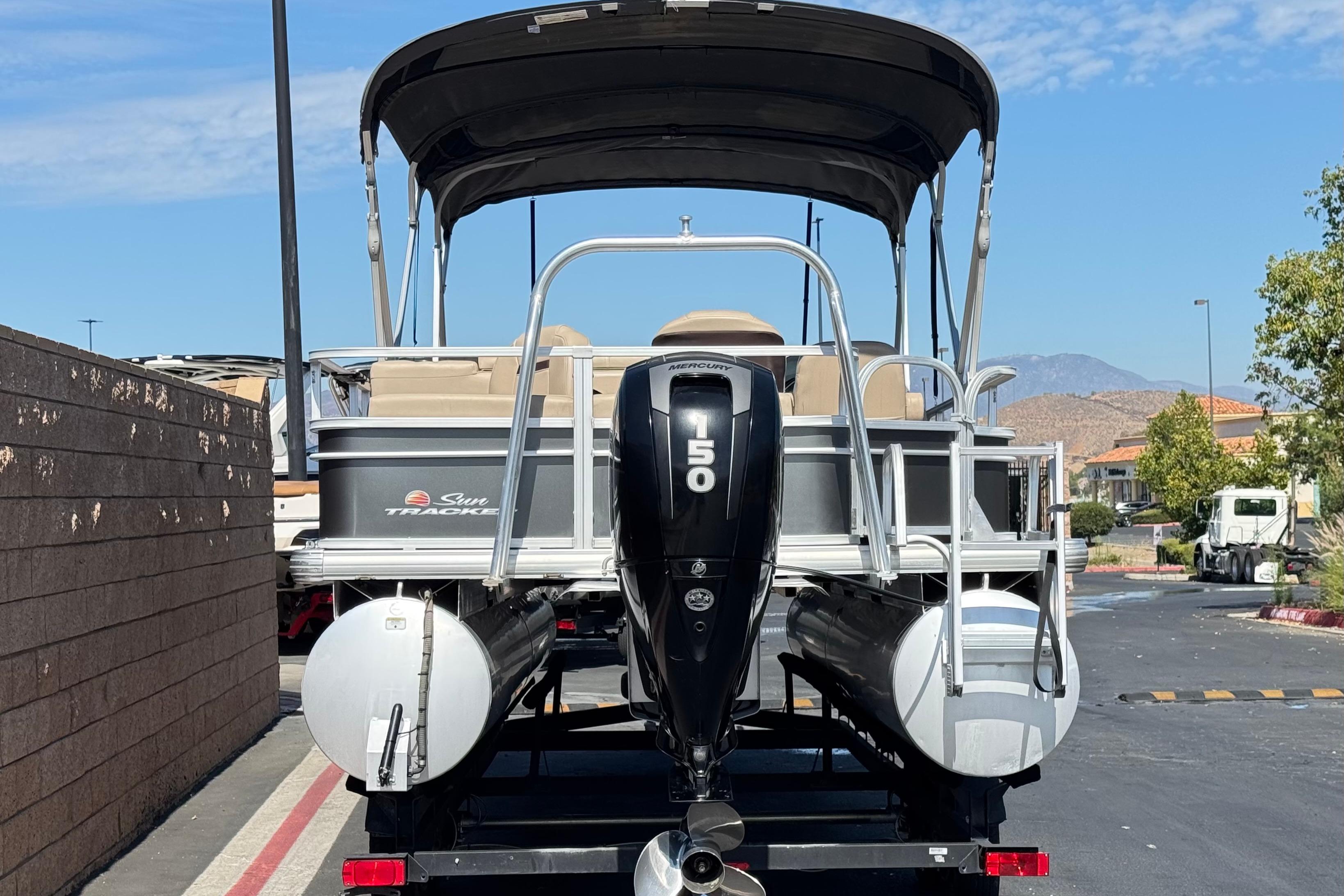 2018 Sun Tracker SportFish 22 DLX pontoon boat with Mercury 150 engine, parked outdoors.