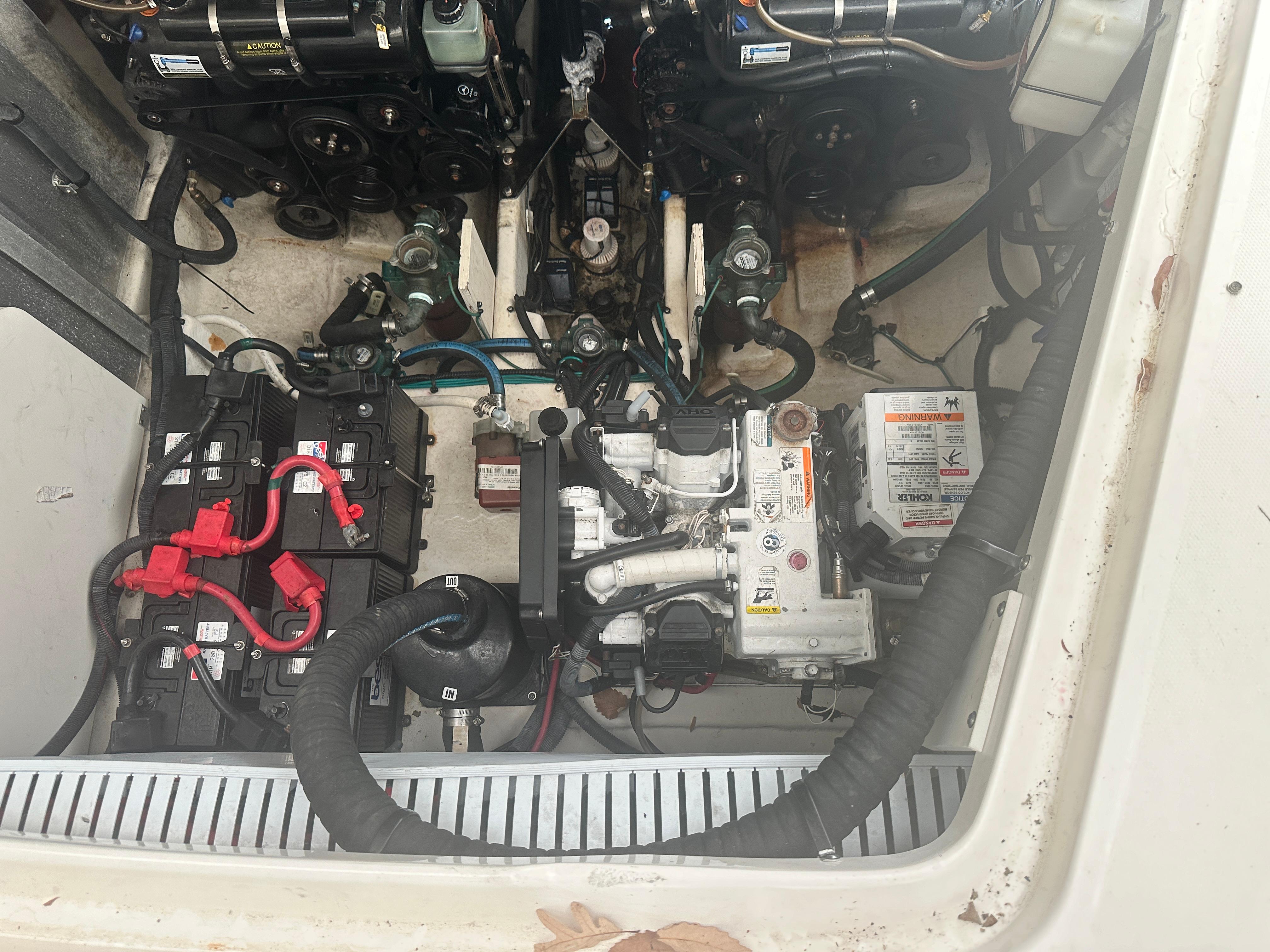 Engine compartment of 2012 Sea Ray 330 Sundancer with visible batteries and mechanical components.