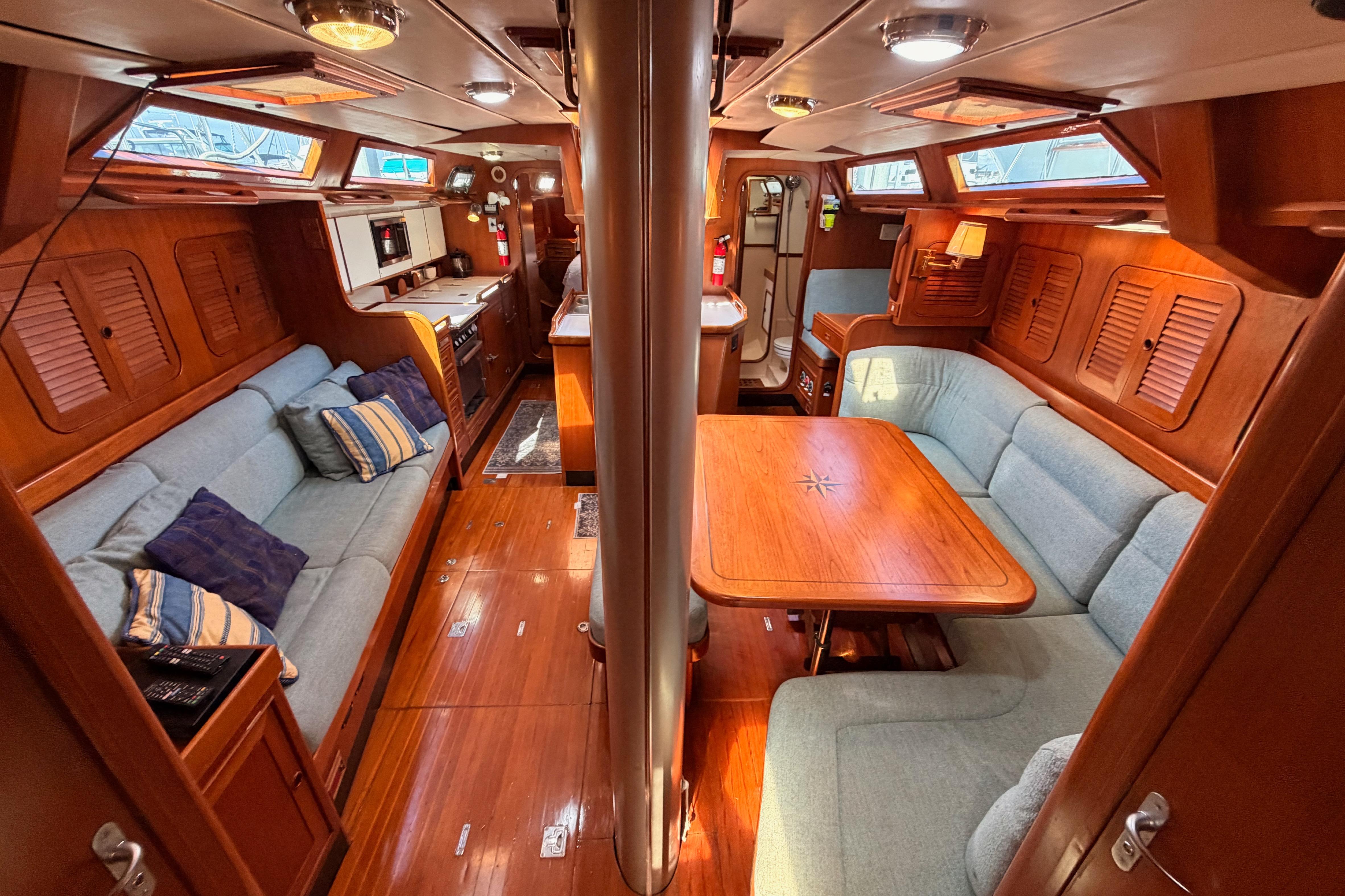Luxurious 1991 Hylas 51 yacht interior with cozy seating and elegant wood finishes.