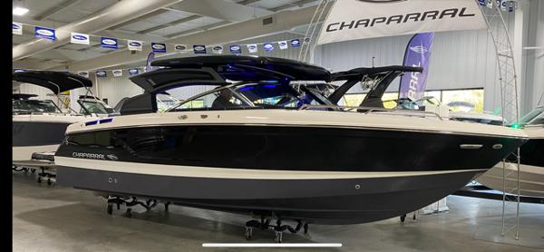2025 Chaparral 267 SSX boat displayed in showroom, sleek black and white design.