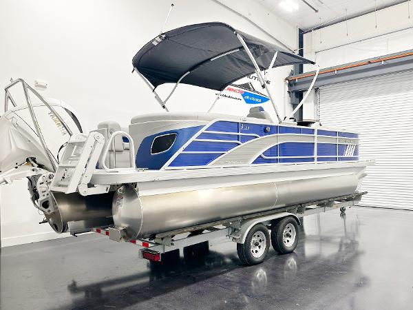2025 Bennington 23LFBCSR pontoon boat on trailer in indoor showroom.