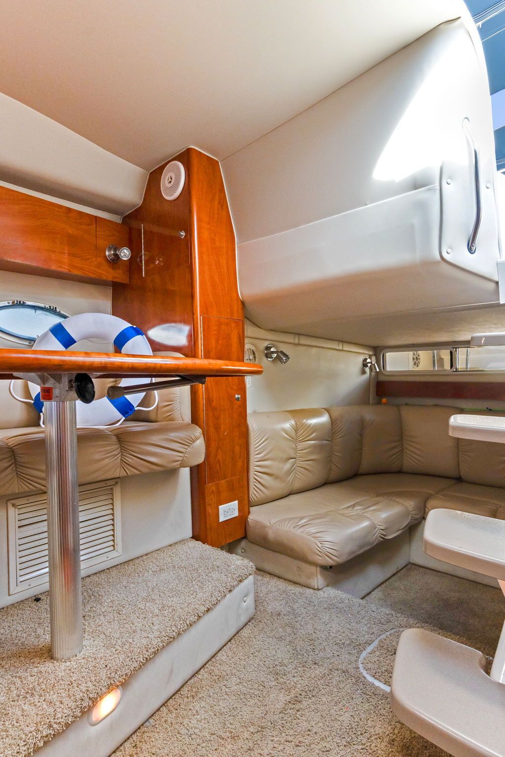 Interior of a 2007 Larson Cabrio 330 with beige upholstery and wood accents.