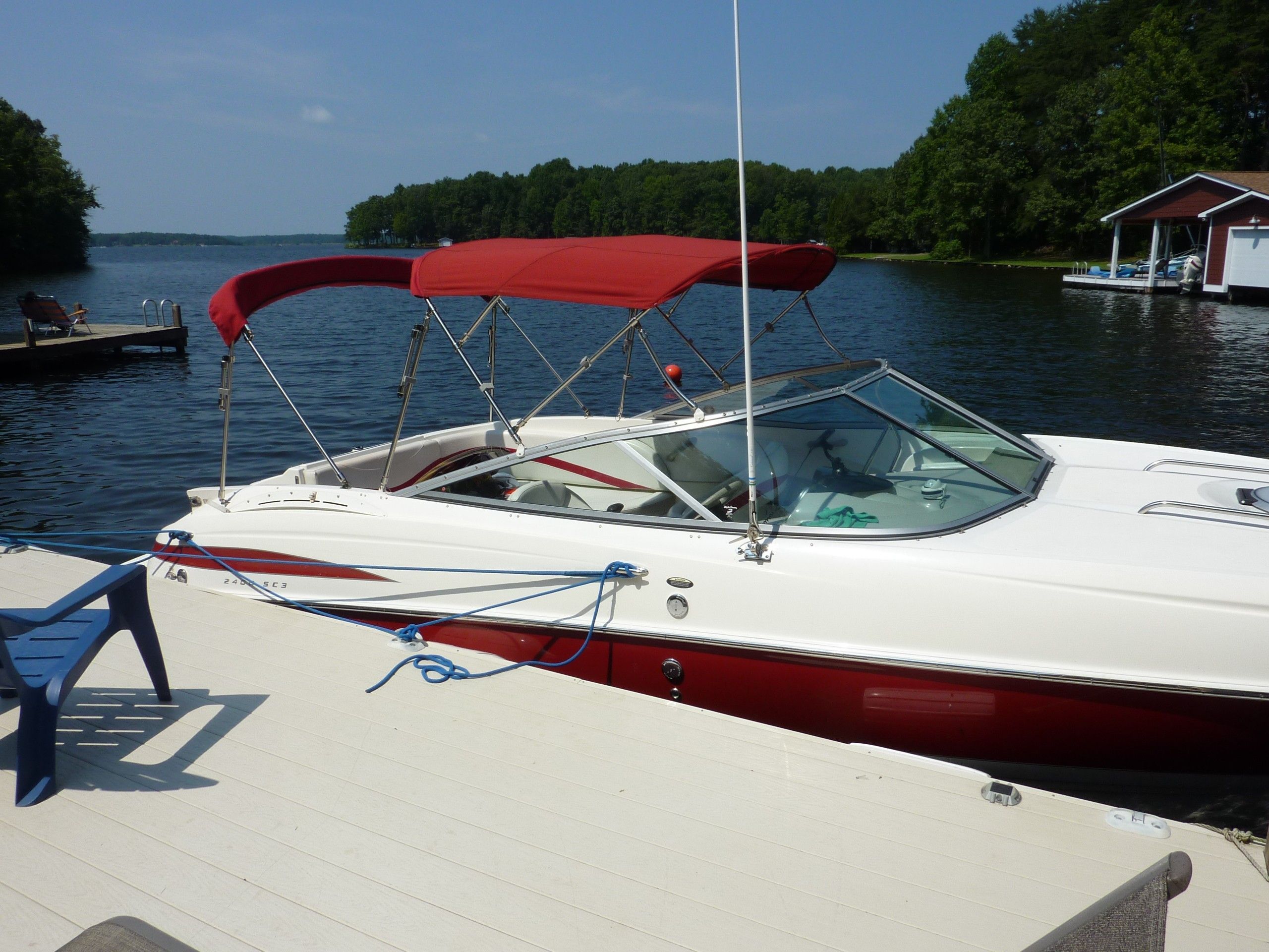 2005 Maxum 2400 SC3 boat docked lakeside with red canopy.