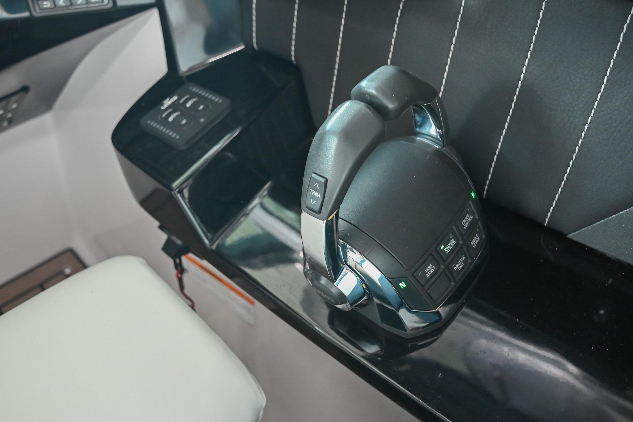 Control panel of a 2014 Four Winns H290 boat with sleek black and chrome design.
