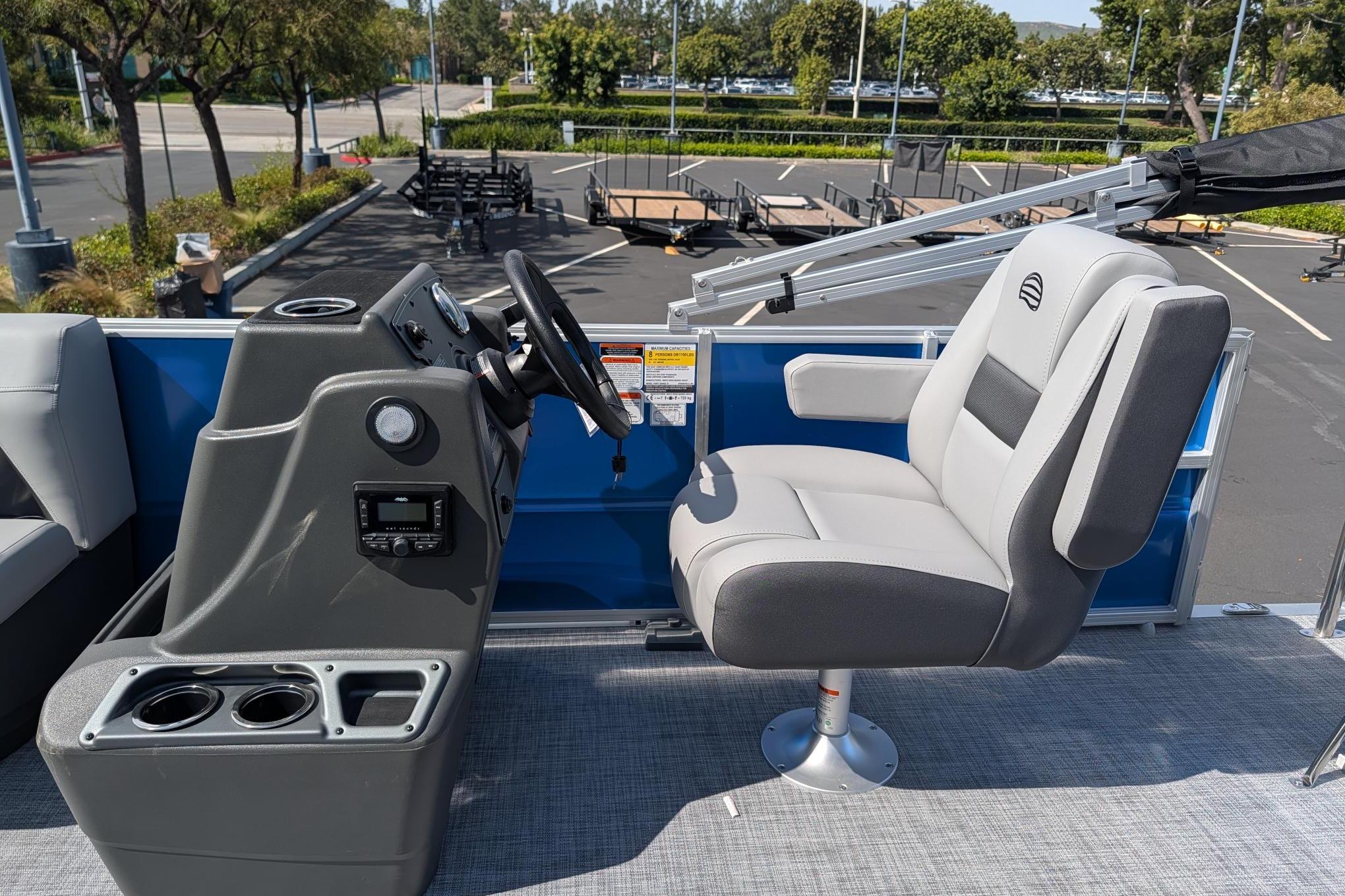 2026 Sun Tracker Party Barge 16 DLX helm with comfortable captain's chair and control panel.