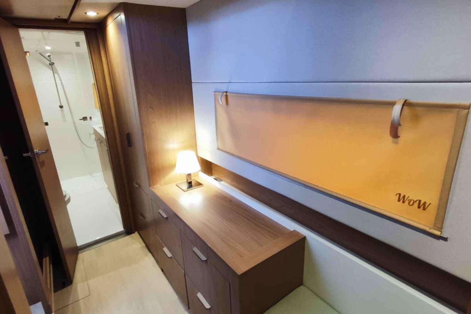 Modern interior of 2025 Bali CATSMART yacht cabin with wooden furniture and ambient lighting.