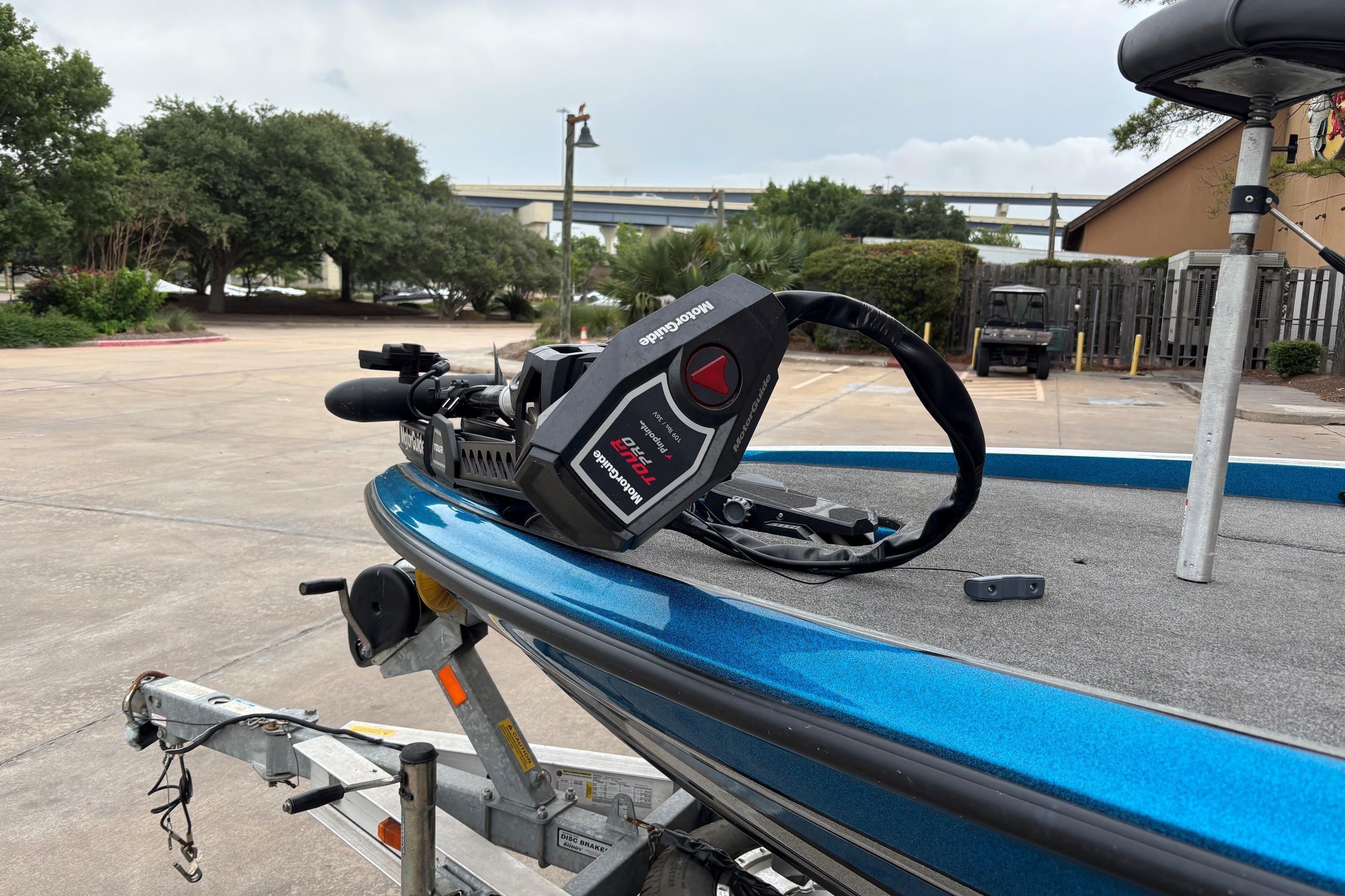 2009 Triton 22 TrX boat on trailer with Minn Kota trolling motor in parking lot.