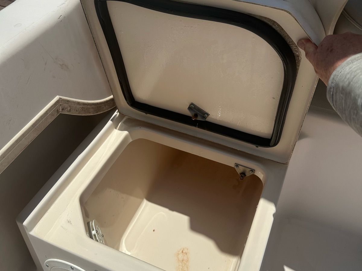 An open storage compartment on a 1998 Grady-White Adventure 208 boat.