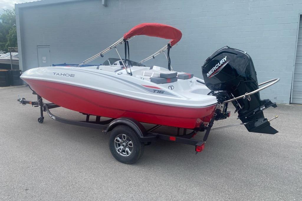 2026 Tahoe T16 boat with red hull and Mercury outboard motor on trailer.