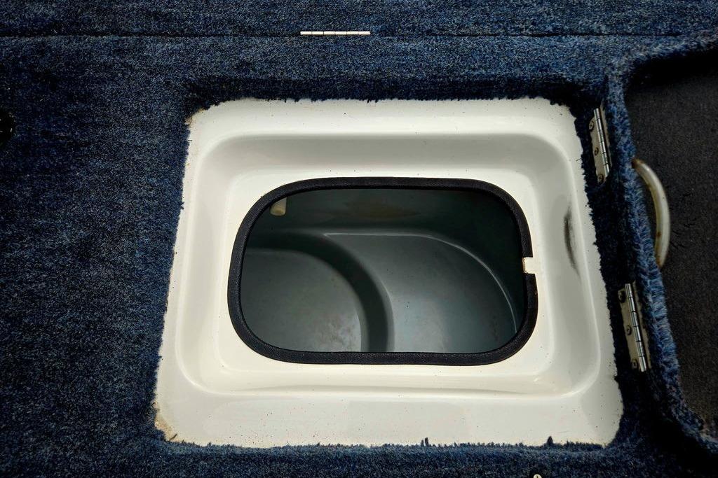 1996 Champion 181 SX boat storage compartment with blue carpeted interior.