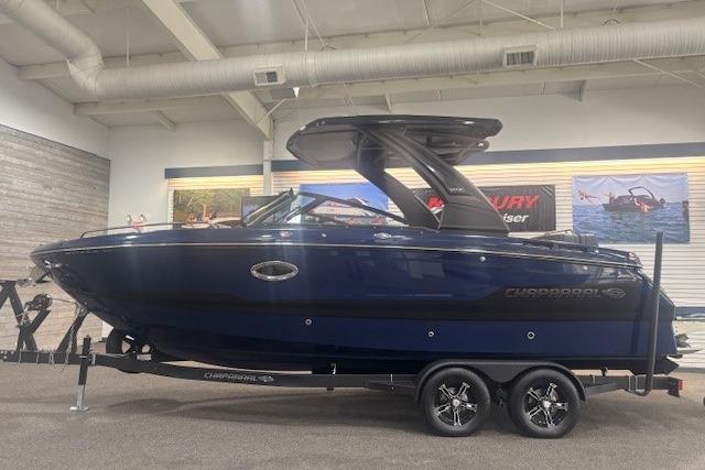 2026 Chaparral 6 SSX boat in showroom, sleek design, dark blue exterior.
