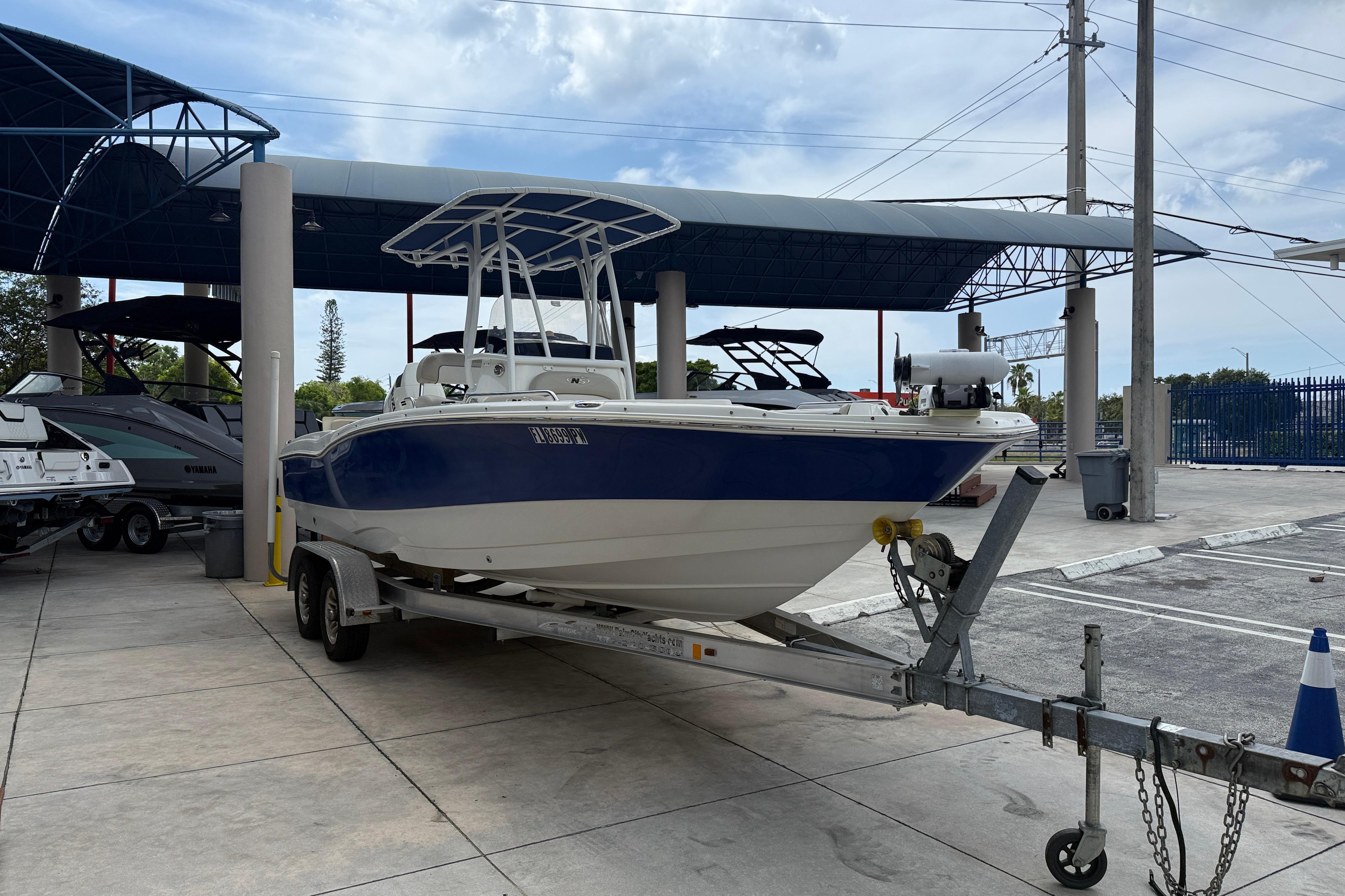 2015 NauticStar 231 Coastal boat on trailer in marina parking area.
