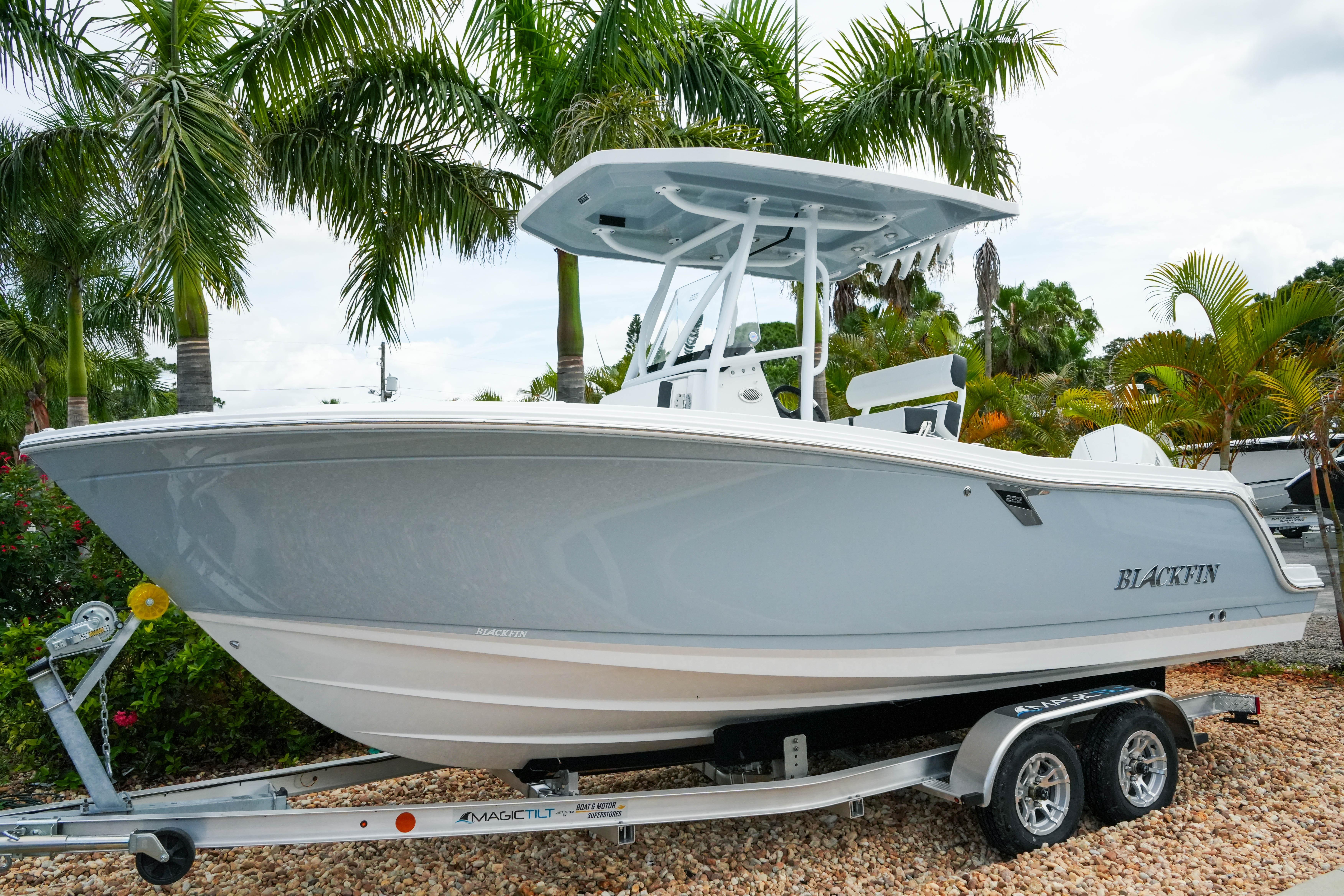 2026 Blackfin 222 CC boat on trailer, surrounded by palm trees.