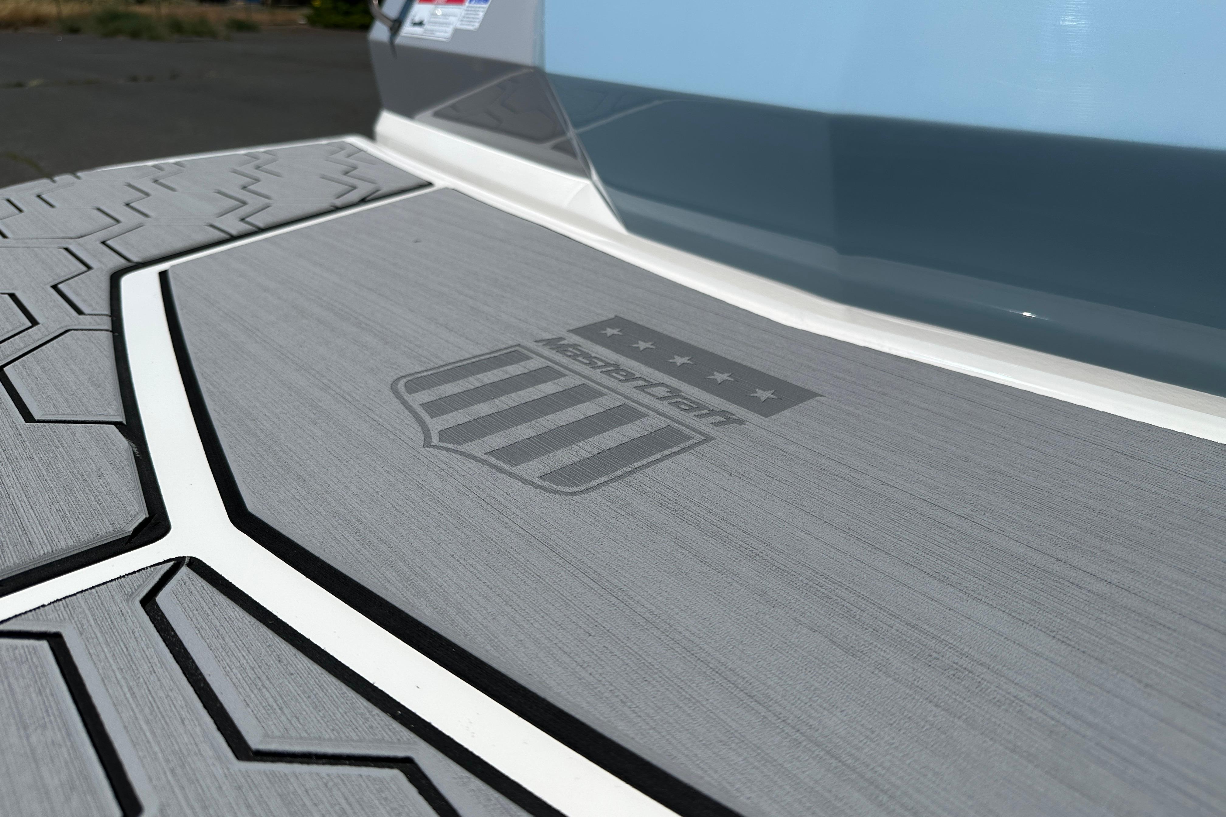 2023 MasterCraft NXT23 boat deck with logo, featuring textured gray surface.