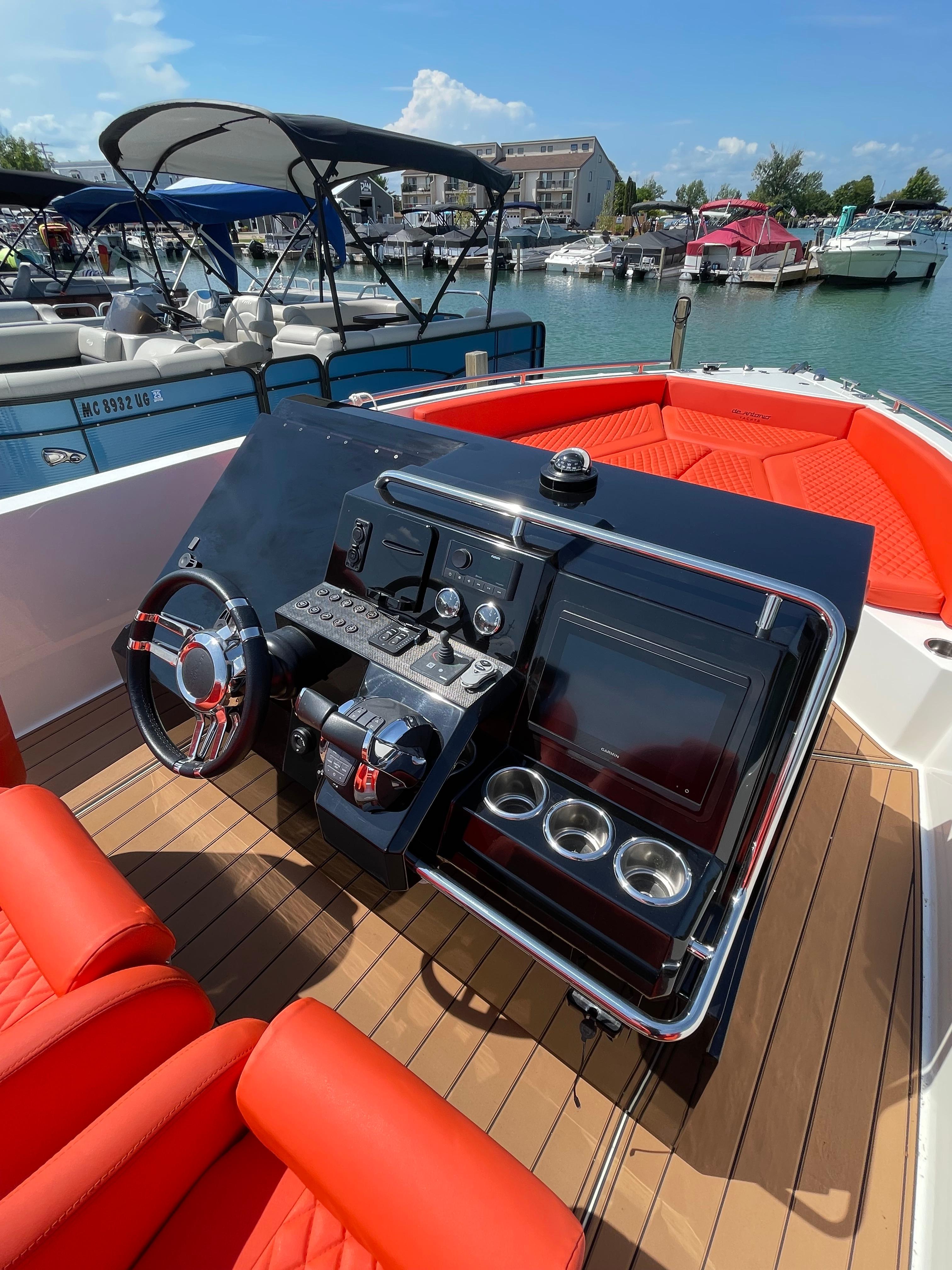2020 De Antonio Yachts D 28 boat dashboard with red seating, docked at marina.