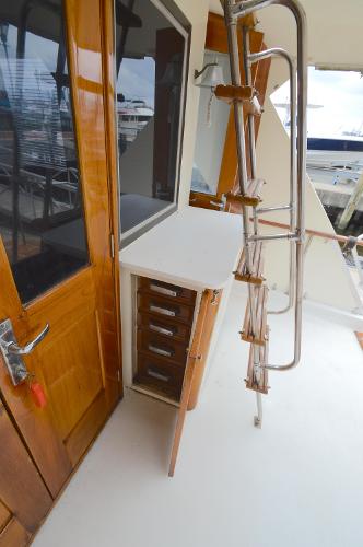 A section of the deck on a 1980 Hatteras 53 Yacht Fisherman with wood details and a ladder.