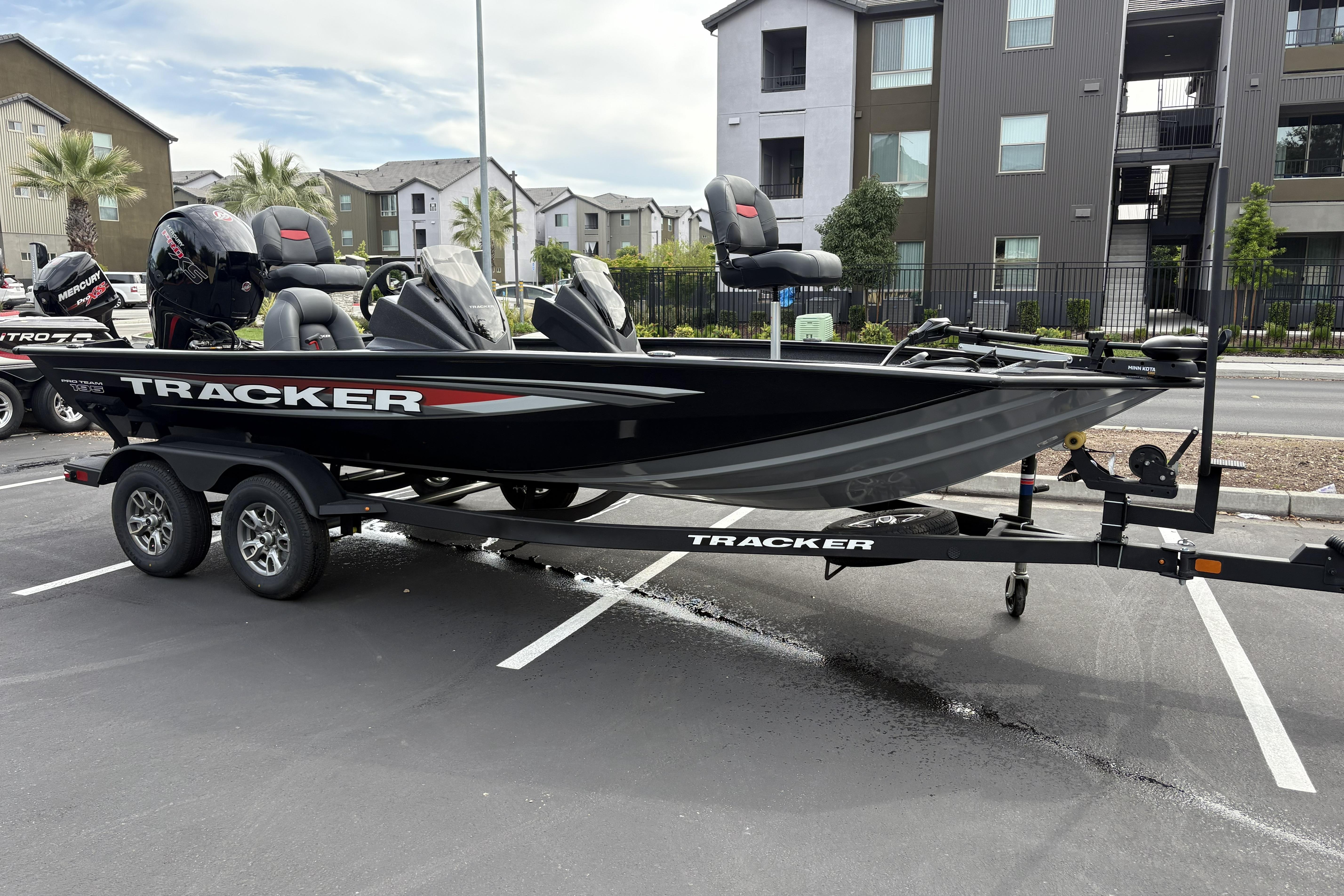2026 Tracker Pro Team 195 boat on trailer in urban parking lot.