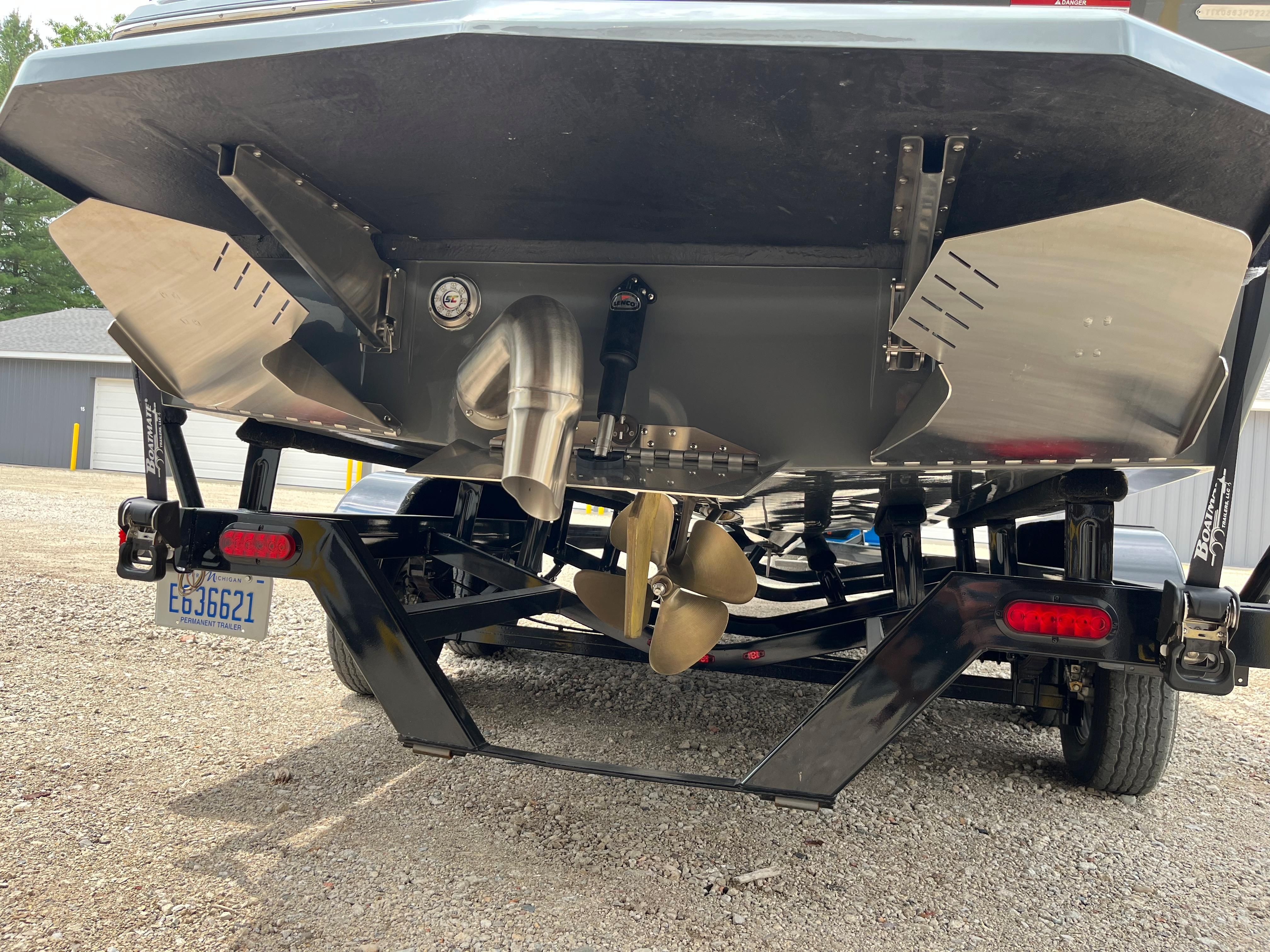 Rear view of a 2022 ATX Surf Boats 22 Type-S on a trailer, showing propeller and exhaust.
