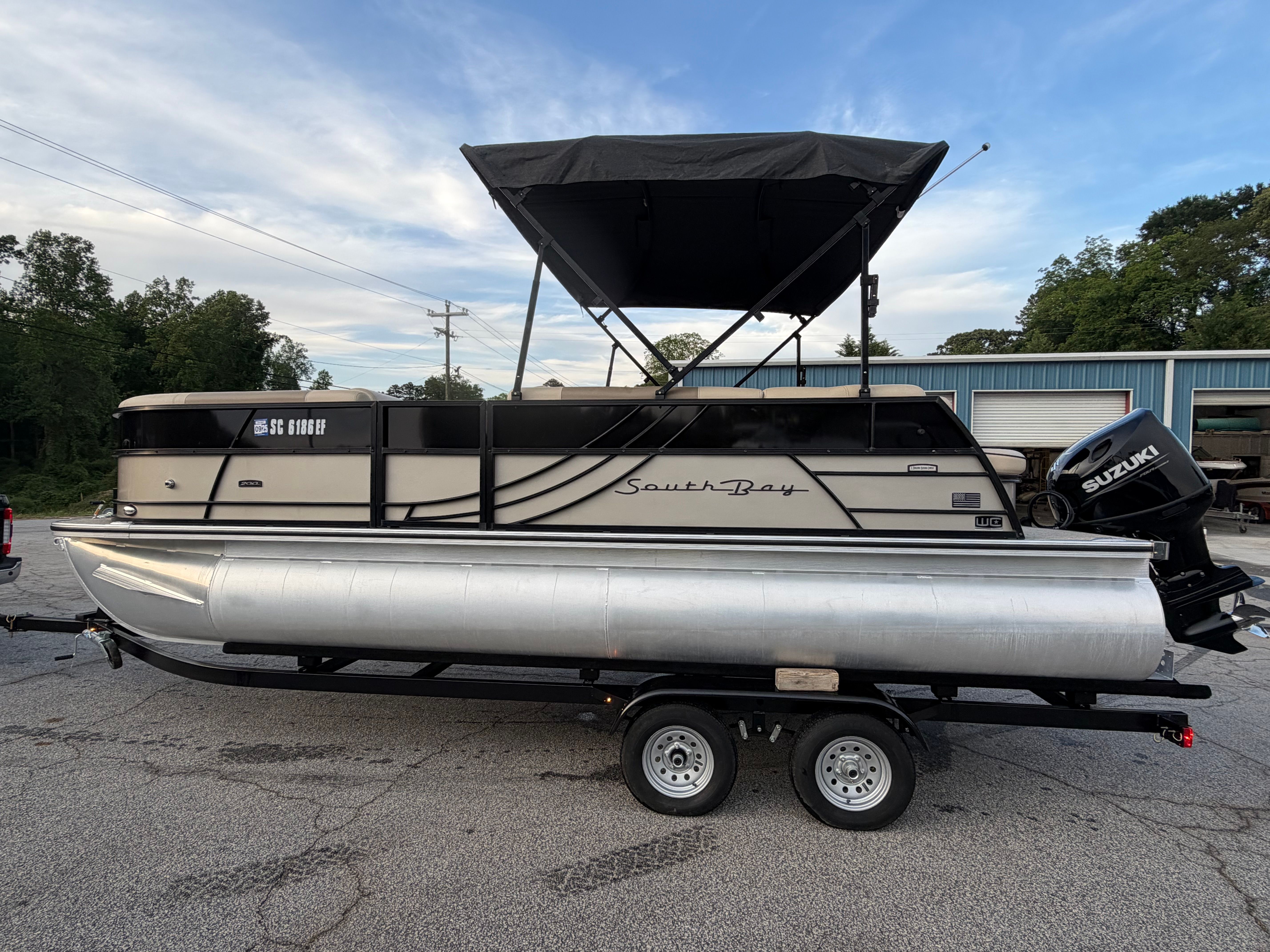 2023 South Bay S222 CR2 pontoon boat with Suzuki motor on trailer.