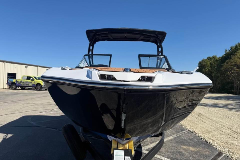 2026 Yamaha Boats 252SD, sleek black hull, parked outdoors under clear blue sky.