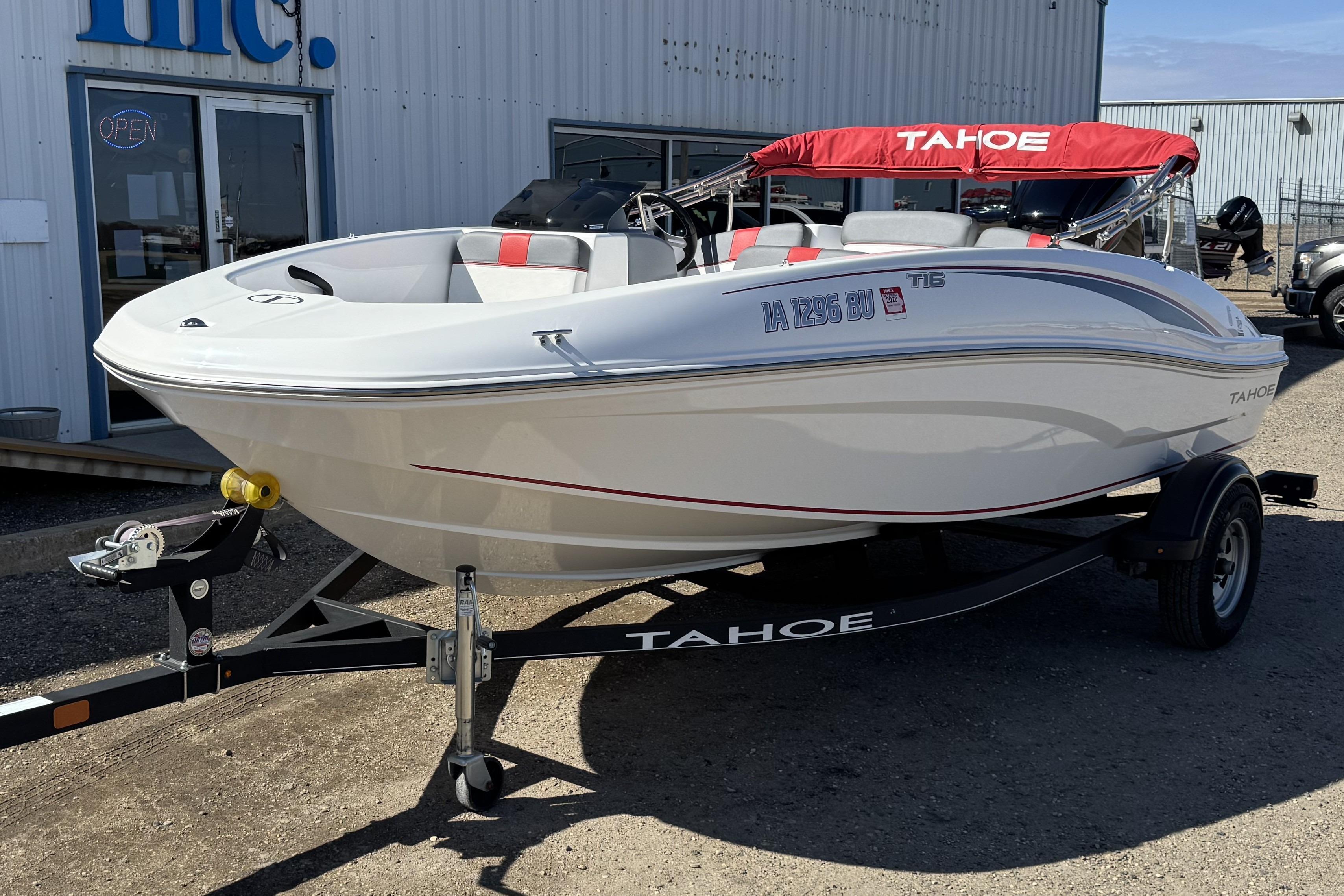 2021 Tahoe T16 boat on trailer, parked outside a building.