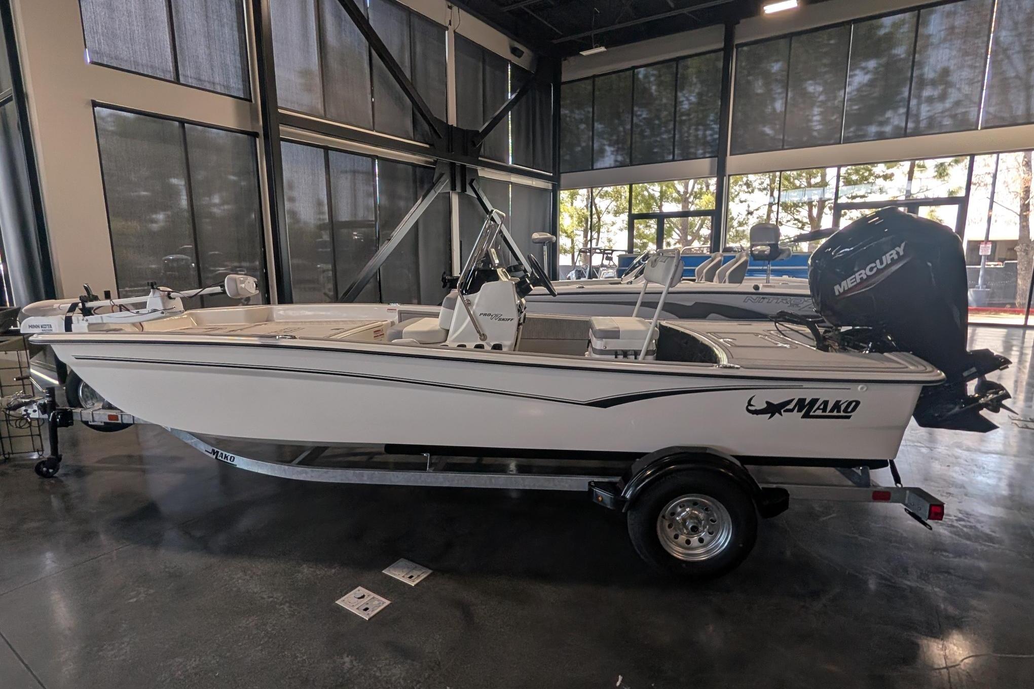 2026 Mako Pro Skiff 17 CC boat displayed indoors with Mercury engine.