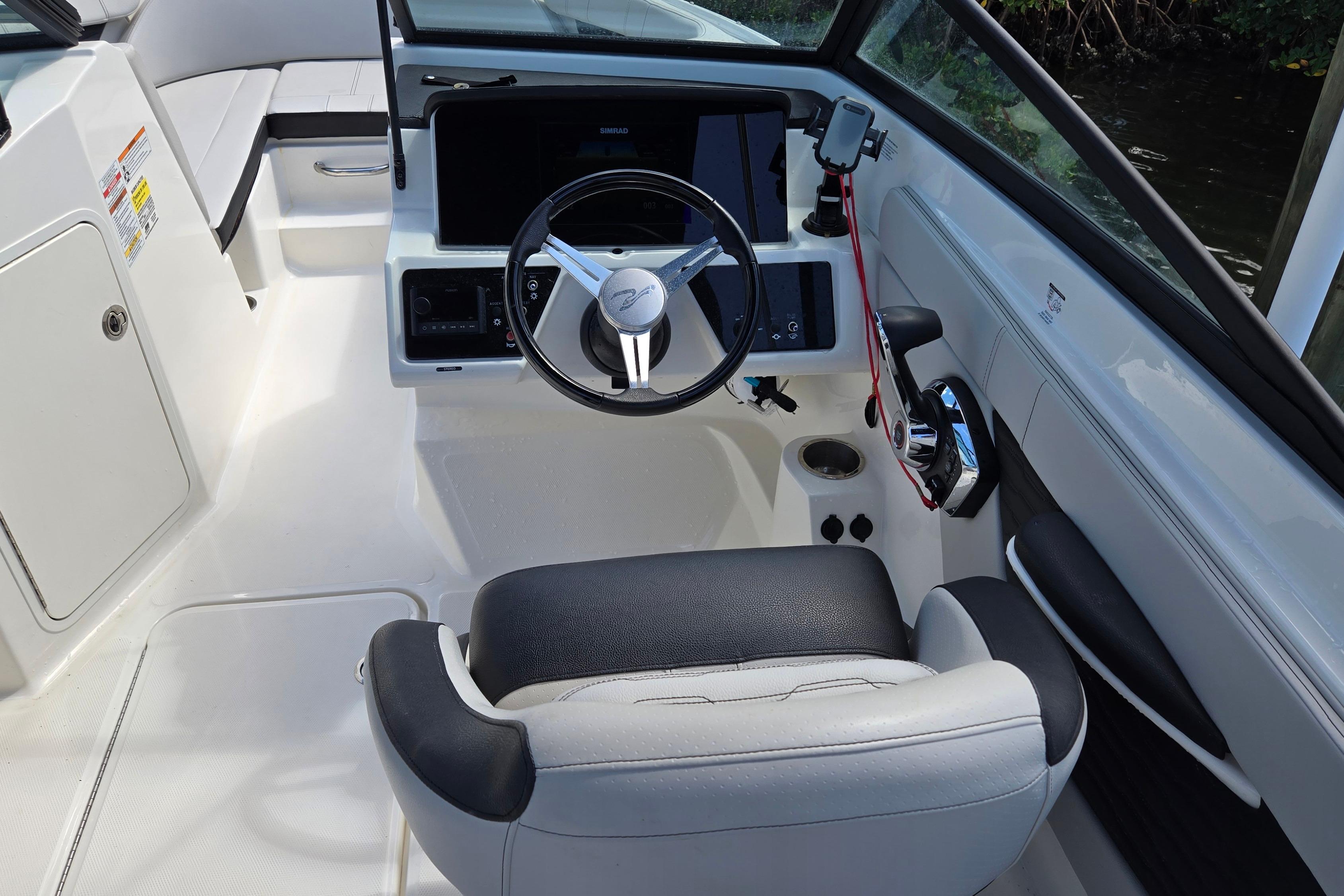 2023 Sea Ray SPX 210 boat cockpit with steering wheel and control panel.