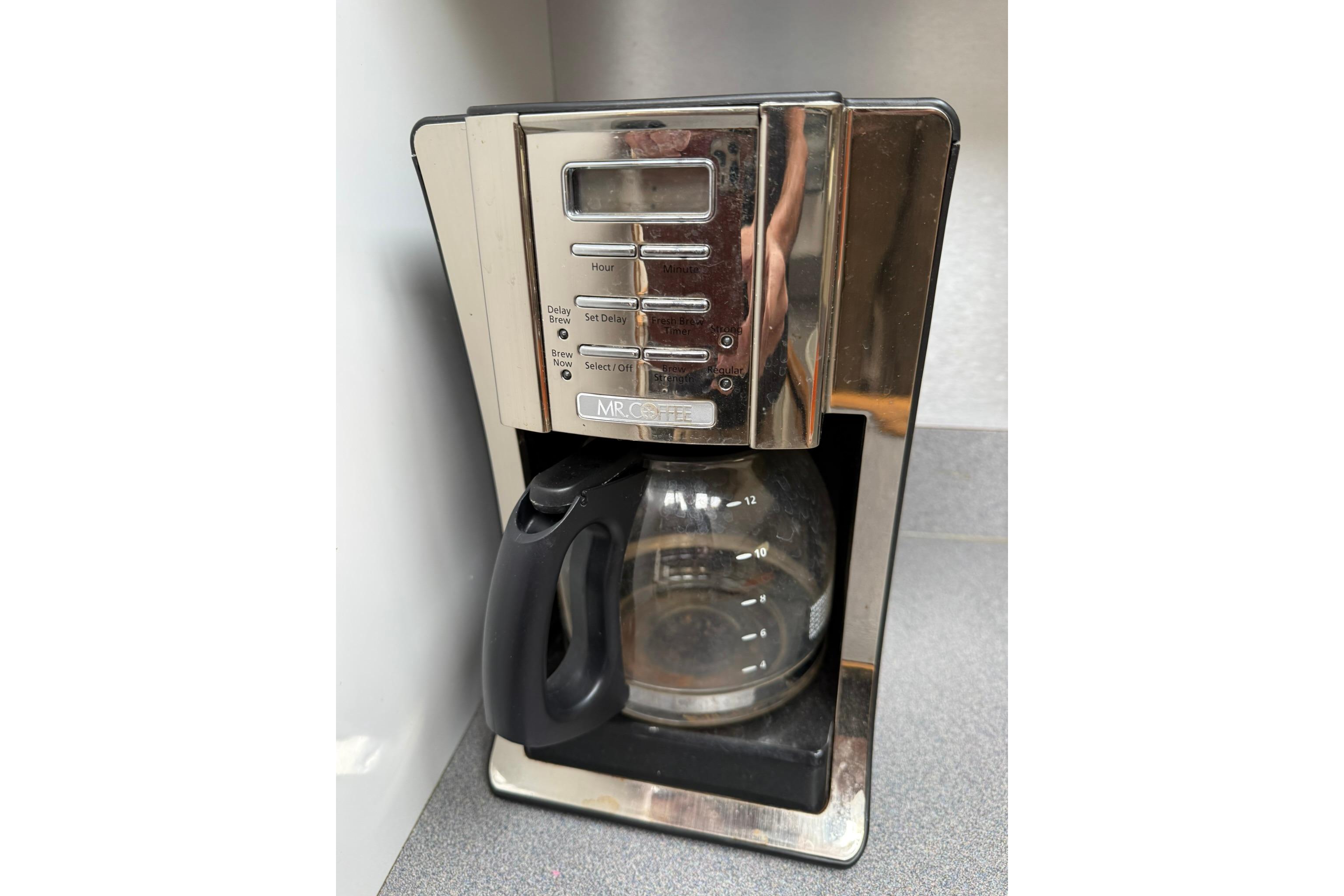 Mr. Coffee machine on countertop, featuring programmable settings and glass carafe.