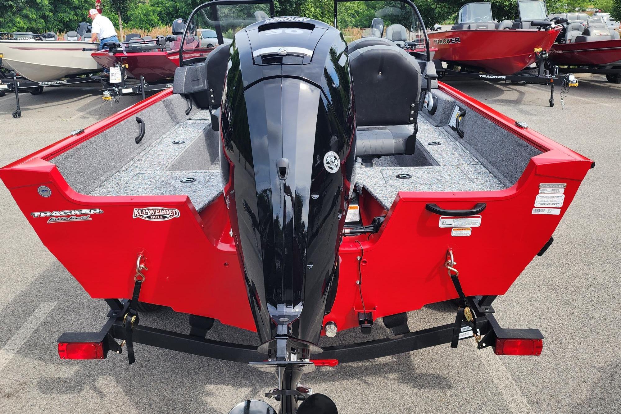 2026 Tracker Pro Guide V-16 WT boat, red exterior, parked with outboard motor.