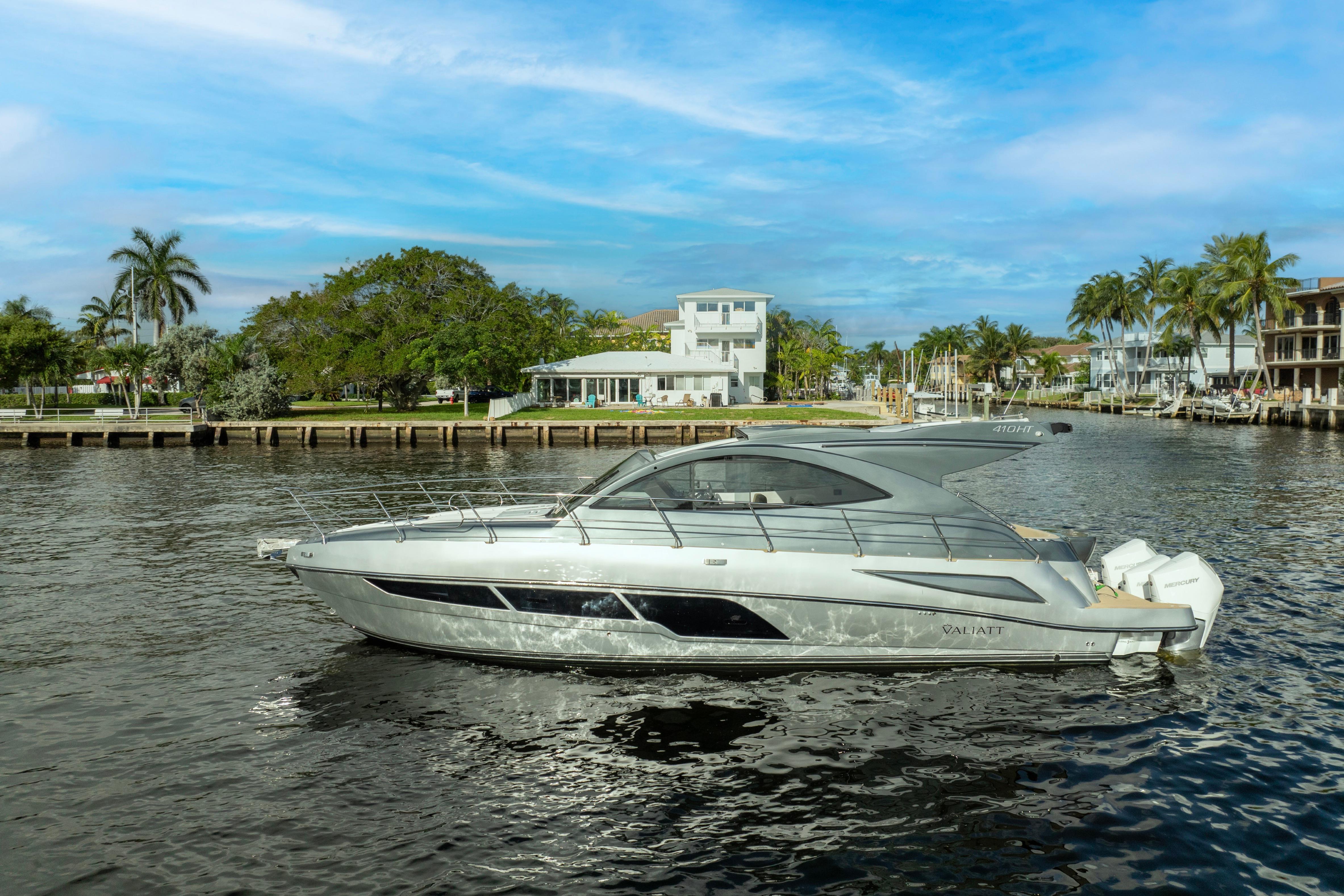 2025 Valiatt 410HT luxury yacht cruising on a scenic waterfront with palm trees.