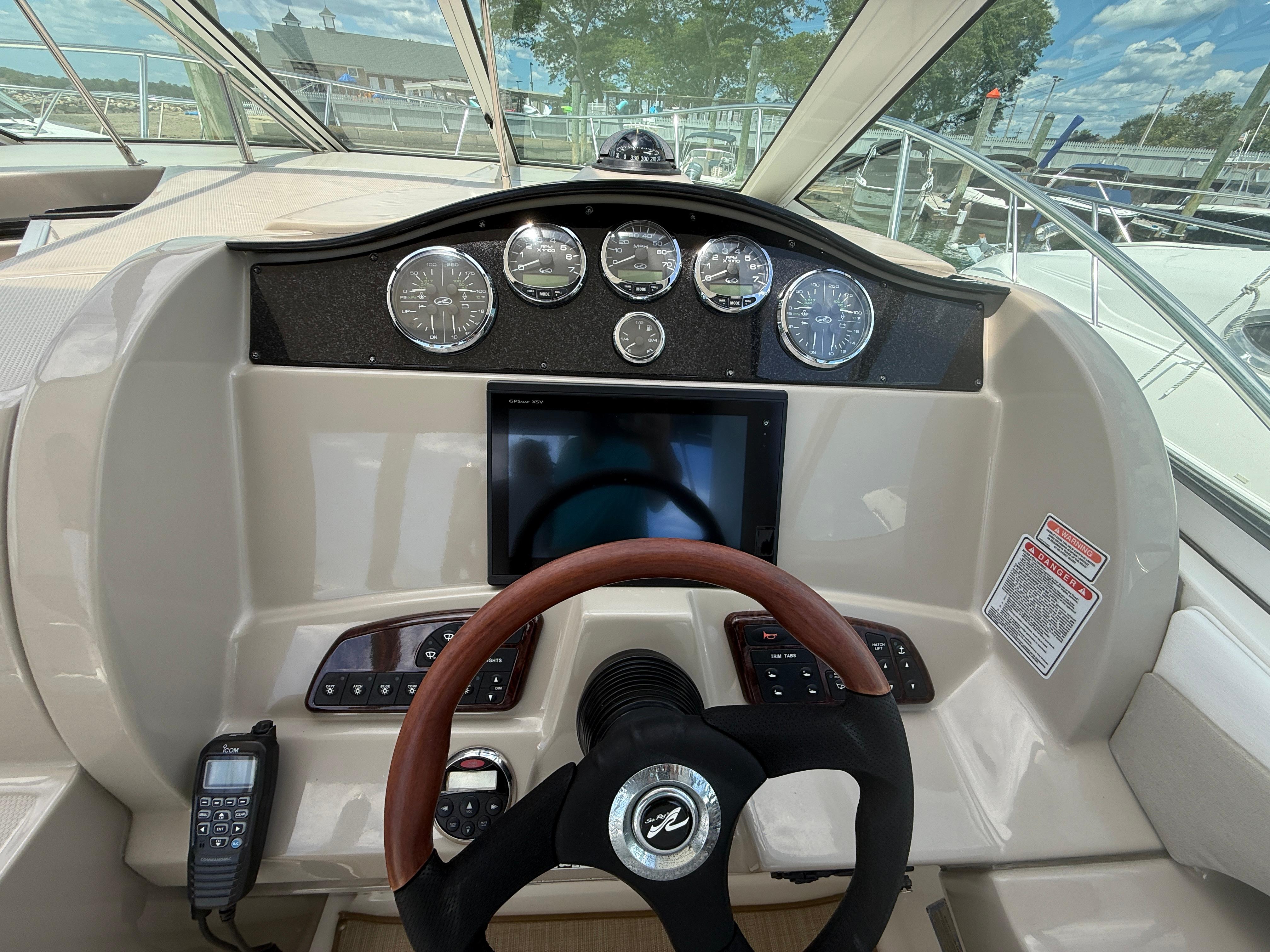 2006 Sea Ray 290 Sundancer helm with gauges, steering wheel, and control panel.