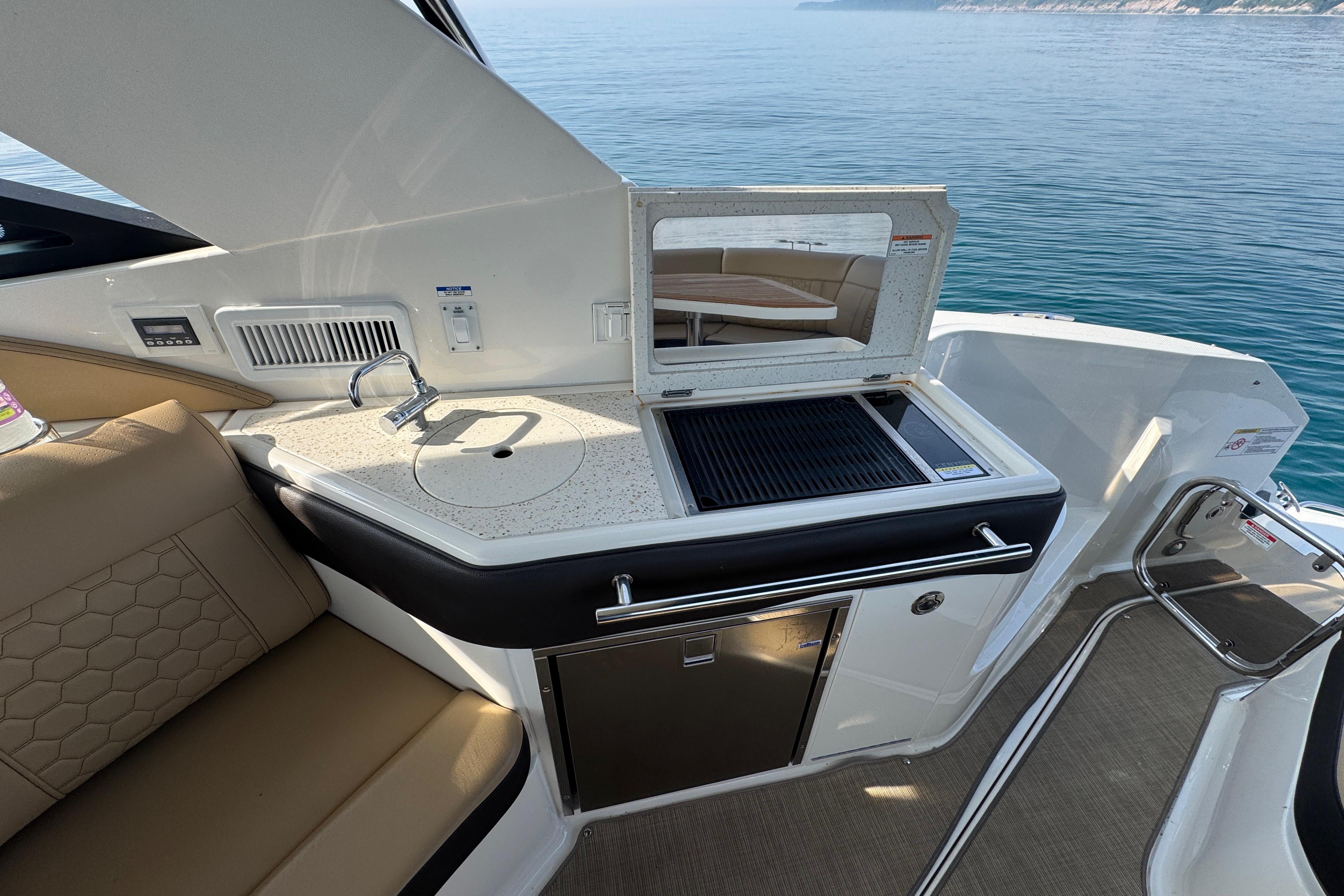 2019 Sea Ray Sundancer 320 yacht interior with kitchenette and seating area.