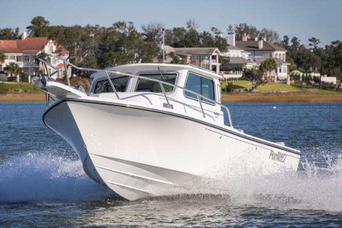Manufacturer Provided Image: 2022 Parker 2120 Sport Cabin boat cruising on water near residential area.