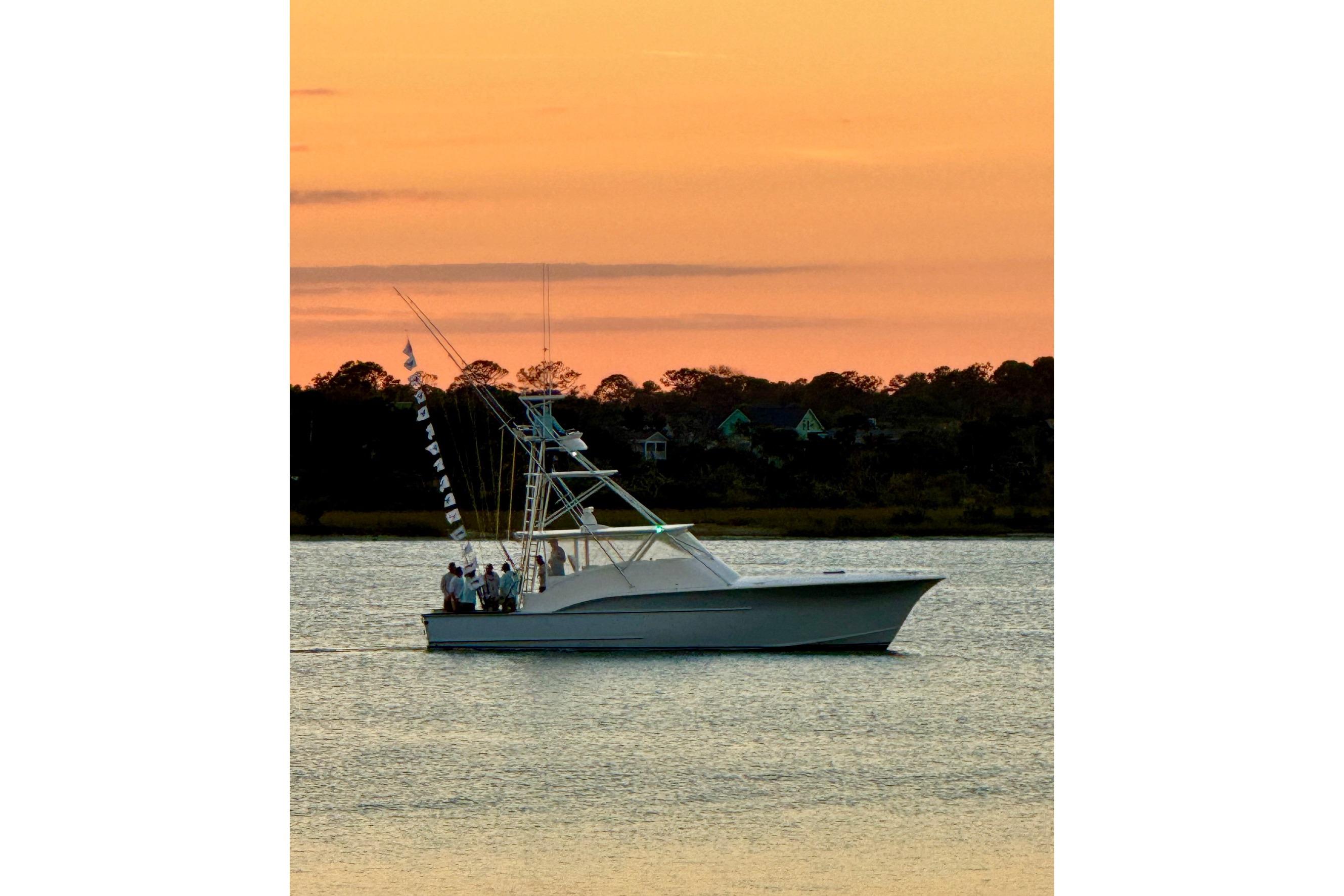 2006 Custom Carolina Heritage Express boat at sunset on calm water.