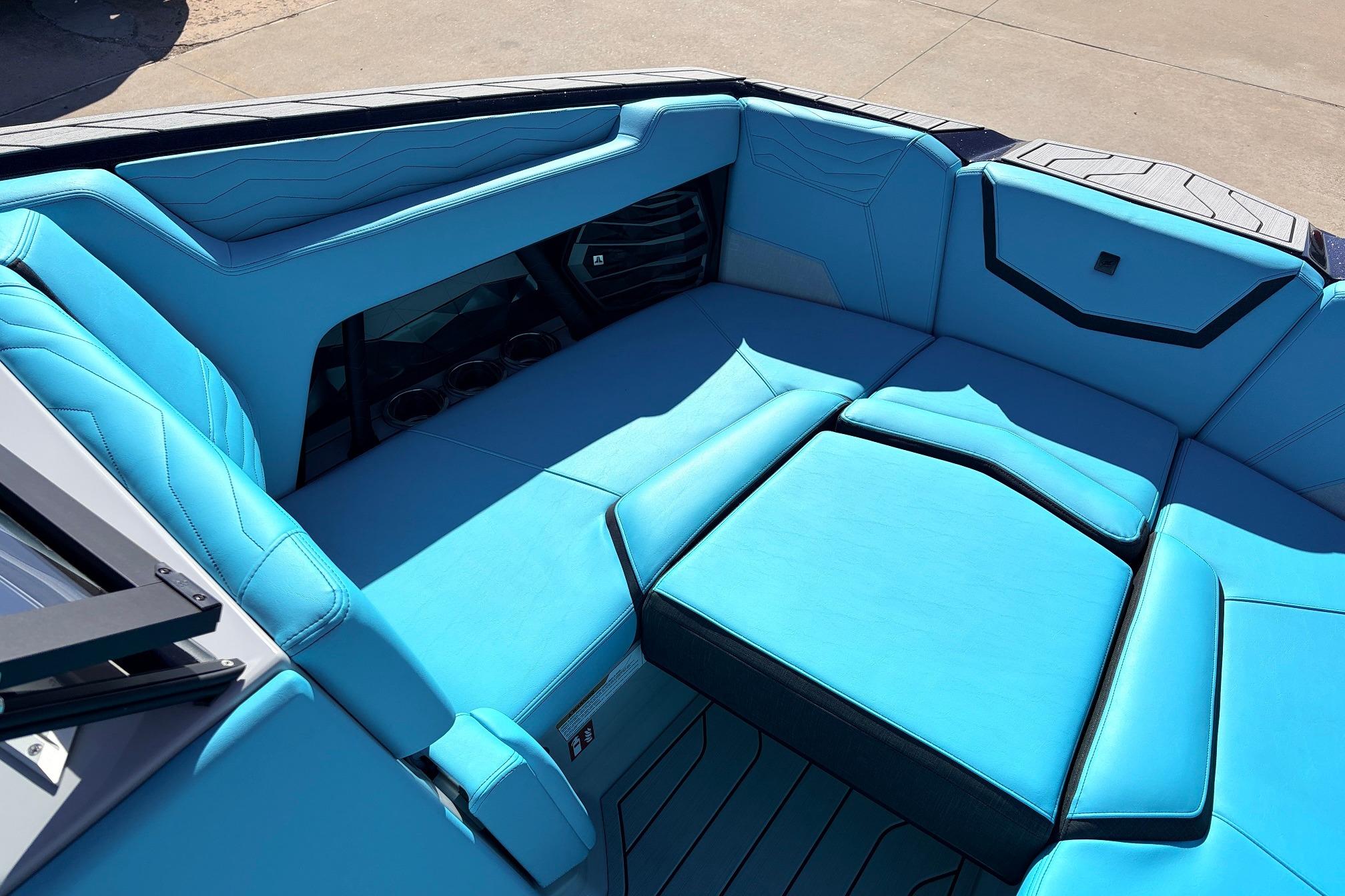 2026 Nautique Super Air Nautique G23 boat interior with vibrant blue seating and cup holders.