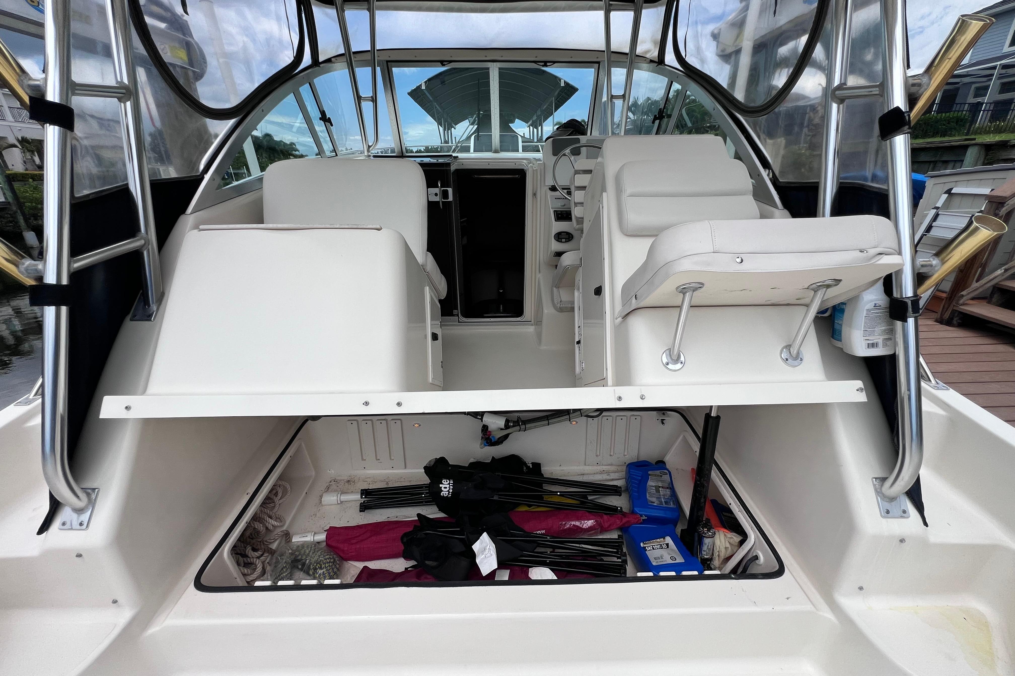 2005 Pursuit 3070 Offshore boat interior with storage compartment open, showcasing seating and equipment.
