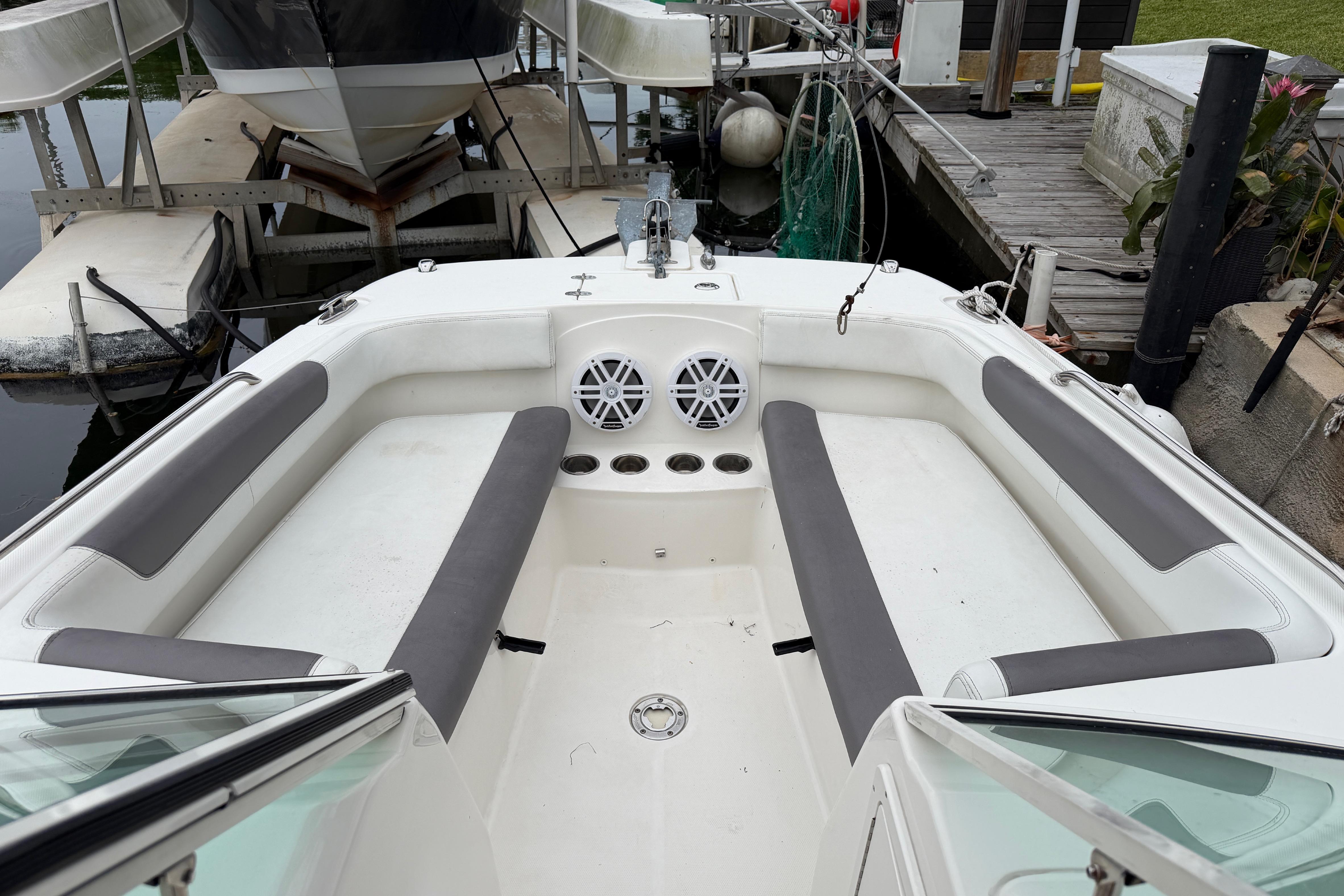 2019 World Cat 230 DC boat interior with seating and speakers at a dock.