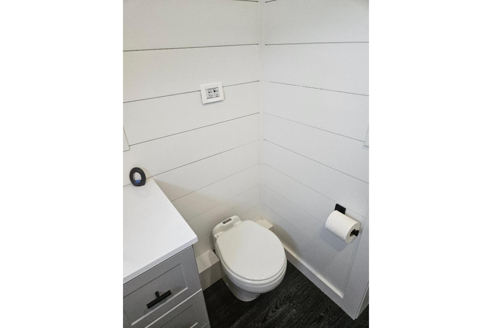 Modern bathroom in 2021 East Coast Houseboats Freedom 40, featuring sleek white shiplap walls.