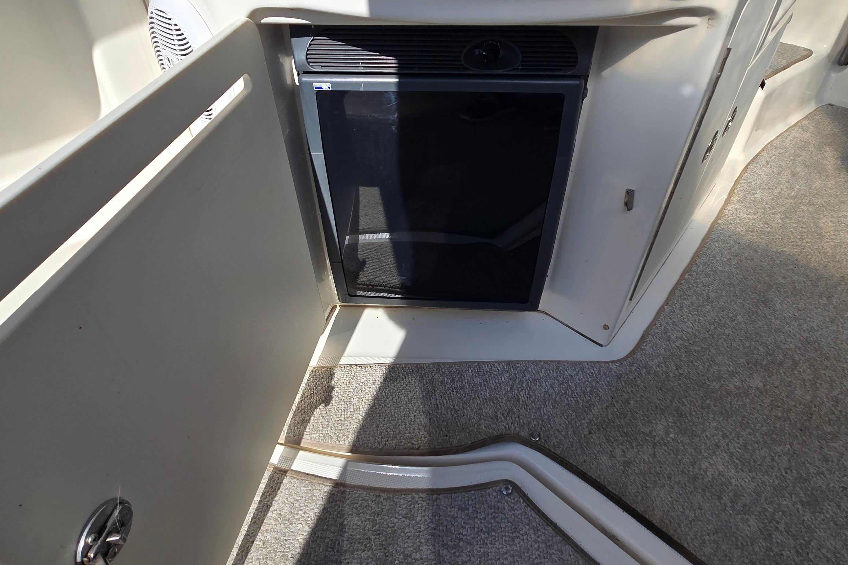2007 Sea Ray 340 Sundancer interior with mini fridge and carpeted flooring.